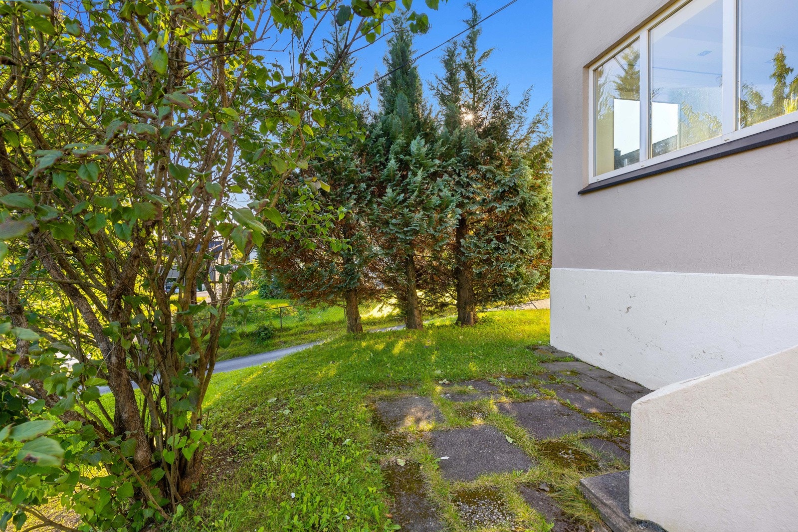 Eiendommen er pent opparbeidet med gressplen og diverse beplantning. Galleribilde