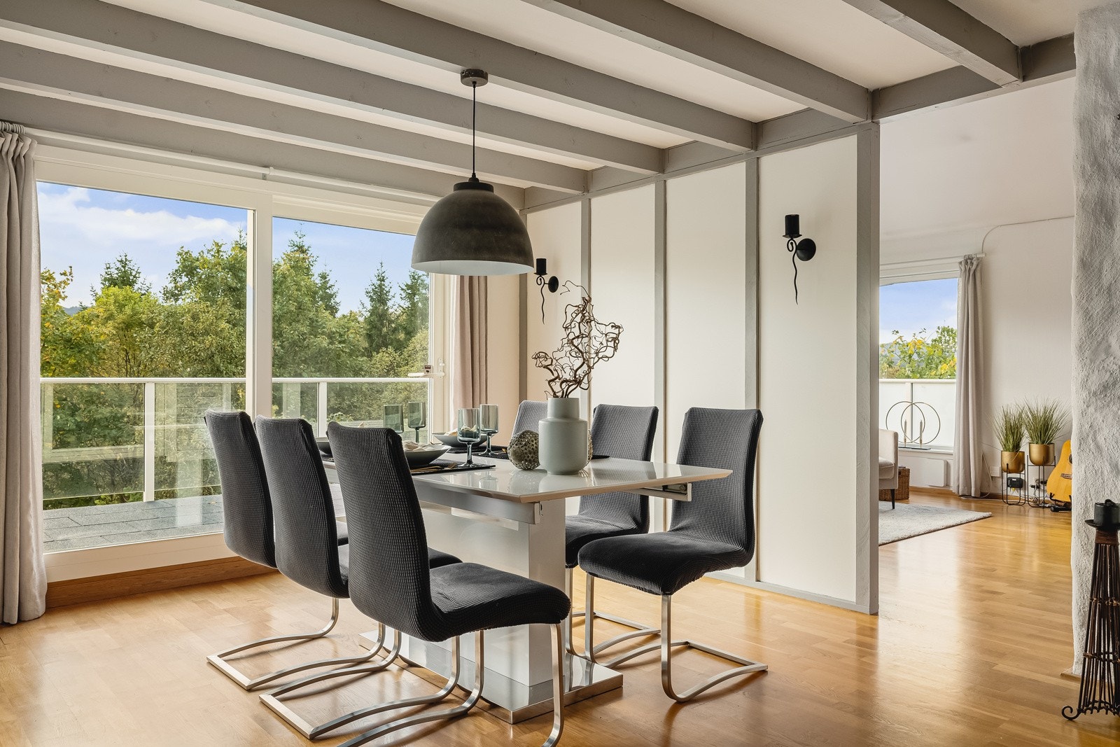 Spisestuesone med store vinduer og skyvedør ut til stor balkong med gummifliser. Galleribilde