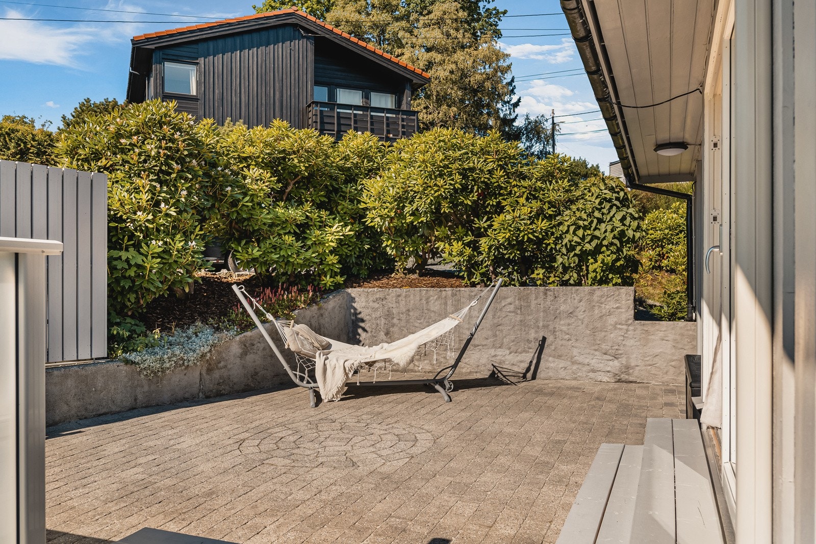 Usjenert og stor hellebelagt terrasse rett utenfor stuen. Lunt og i le for nordavind. Galleribilde