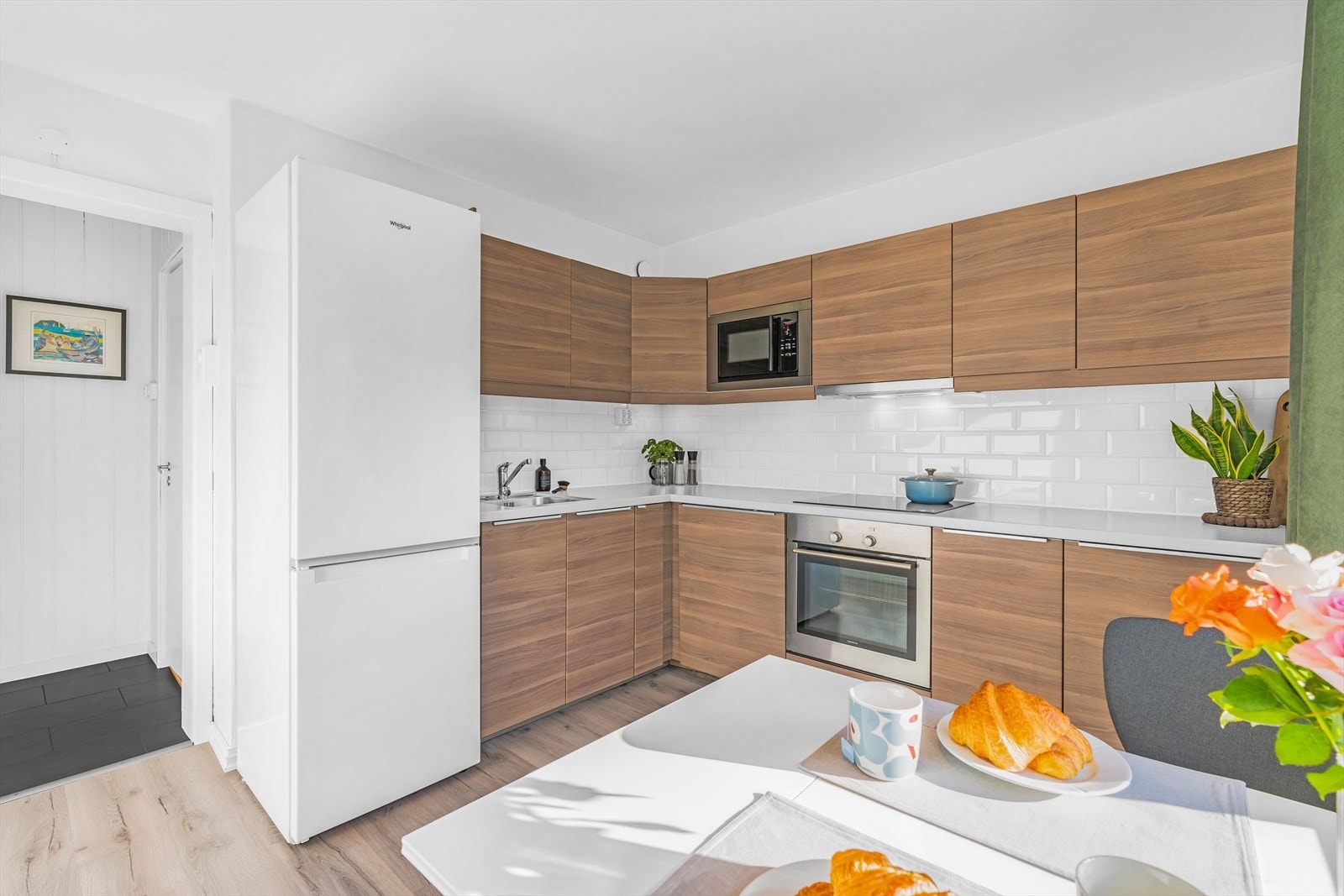 Innredning med glatte fronter og benkeplate av laminat. Det er kjøl/fryseskap, integrert oppvaskmaskin, nedfelt induksjonstopp og innebygget stekeovn Galleribilde
