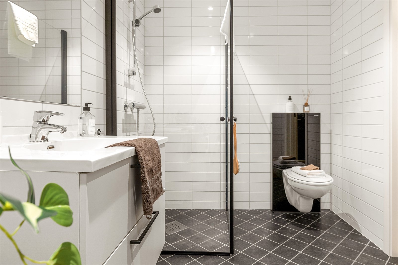 Badet ligger på venstre side av entréen og måler 5,7 kvm. Det er romslig og helfliset med vannbåren gulvvarme og innfelte downlights i tak. Galleribilde