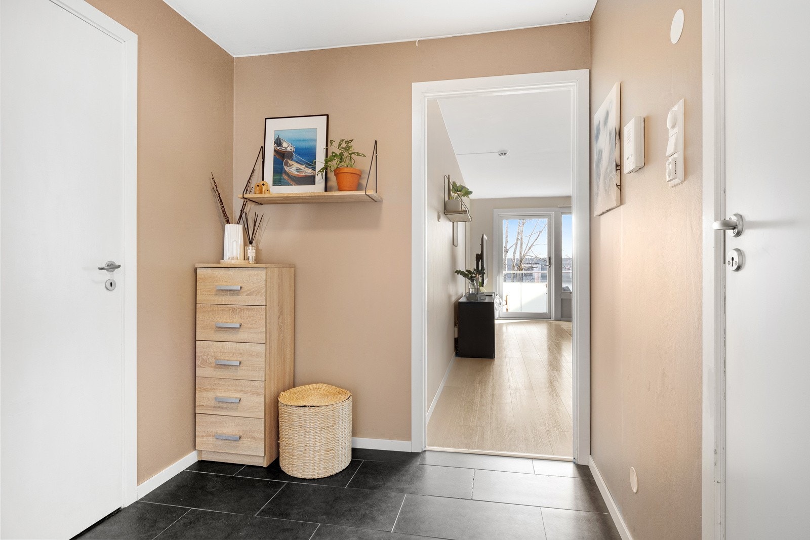 Entreen har mørke fliser på gulv, samt beige veggflater og listefritt tak, en stil som går igjen i øvrige oppholdsrom. Galleribilde