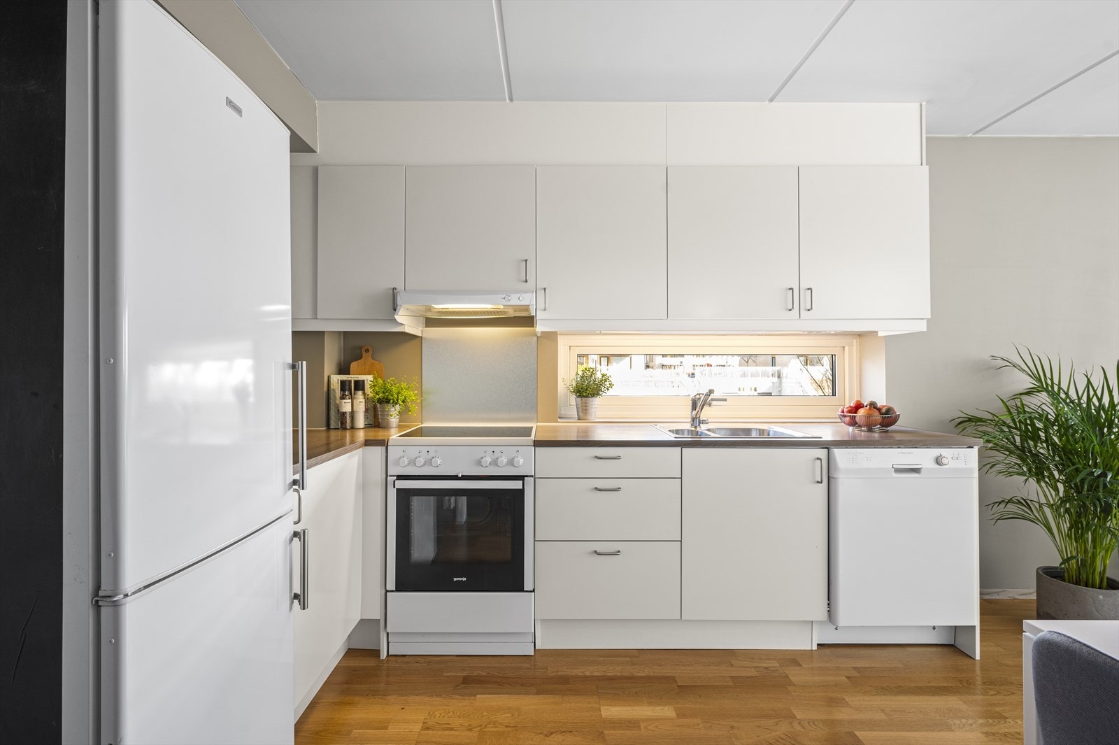 Kjøkkeninnredning med glatte fronter og laminat benkeplate med oppvaskkum. Galleribilde
