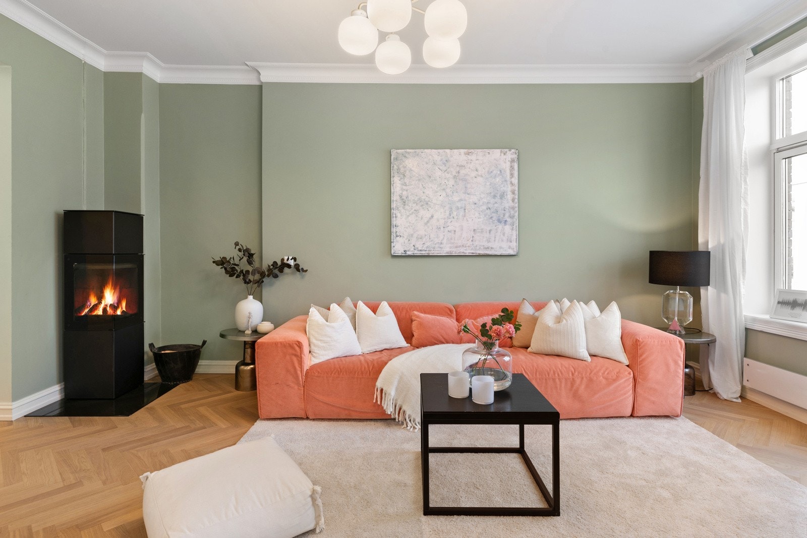 Stuen har klassiske detaljer som fiskebeinsgulv med gulvvarme, stukkatur og rosett, samt pent listverk. I hjørnet av stuen er det plassert en vedovn som varmer godt på kalde høst- og vinterdager Galleribilde