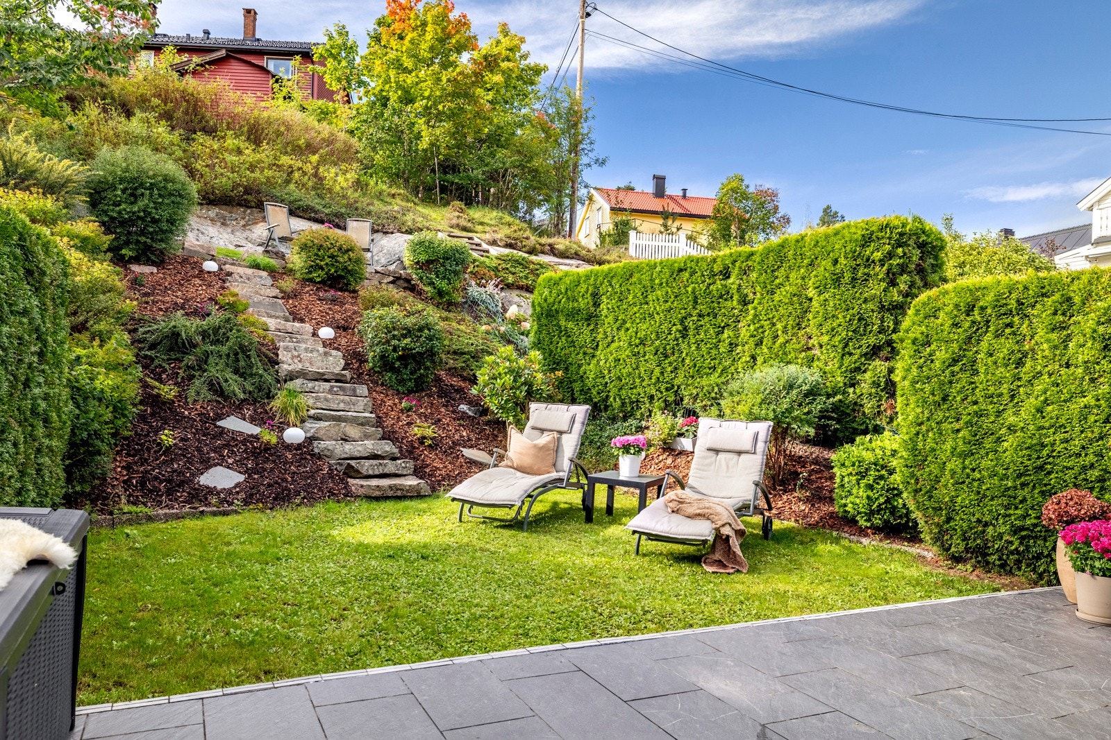 I skråningen opp til nest øverste nivå er det steintrapp og beplantning. Galleribilde