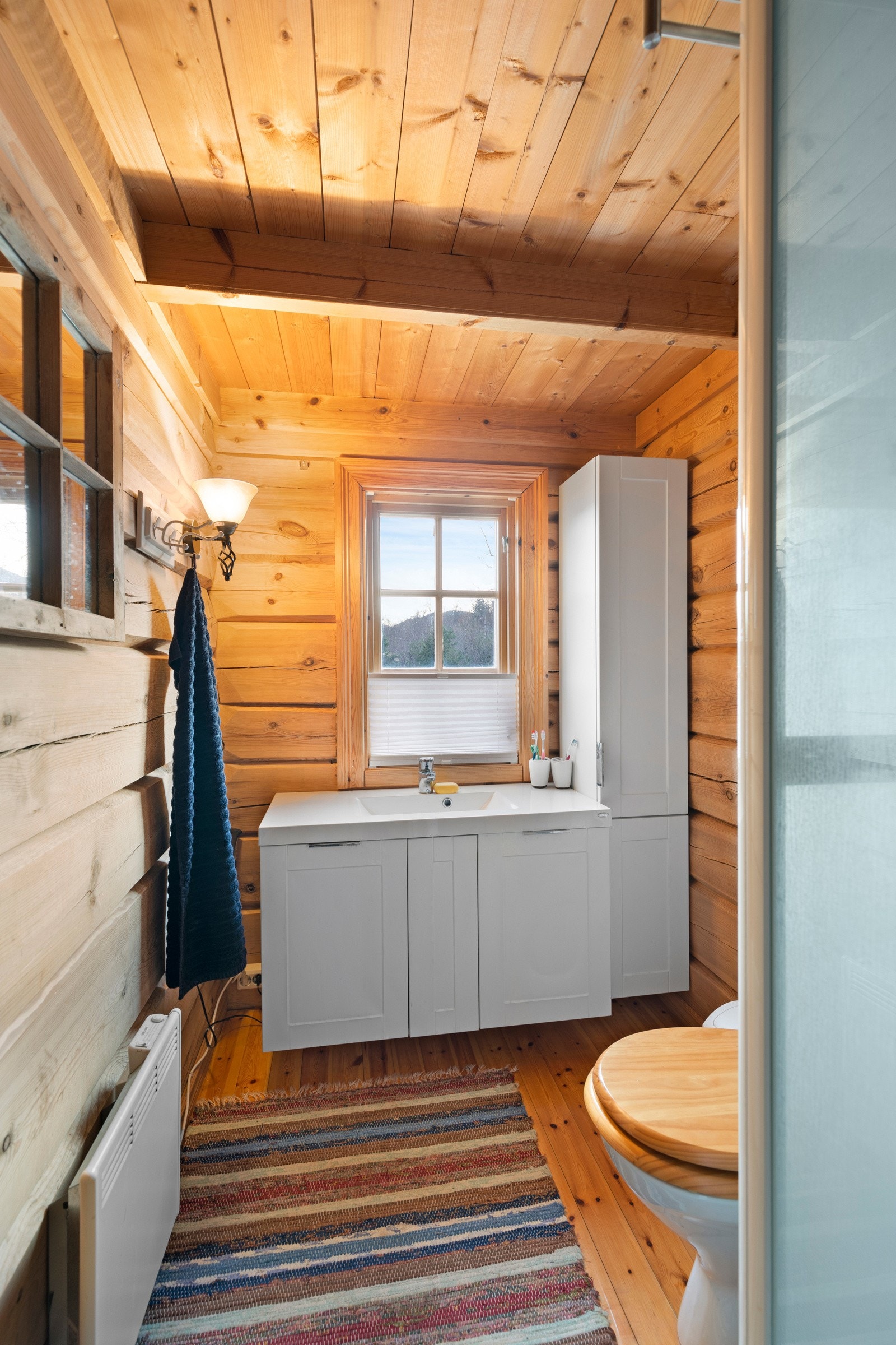 Badet i hytten har trebord på gulv og tømmer på vegger. Galleribilde