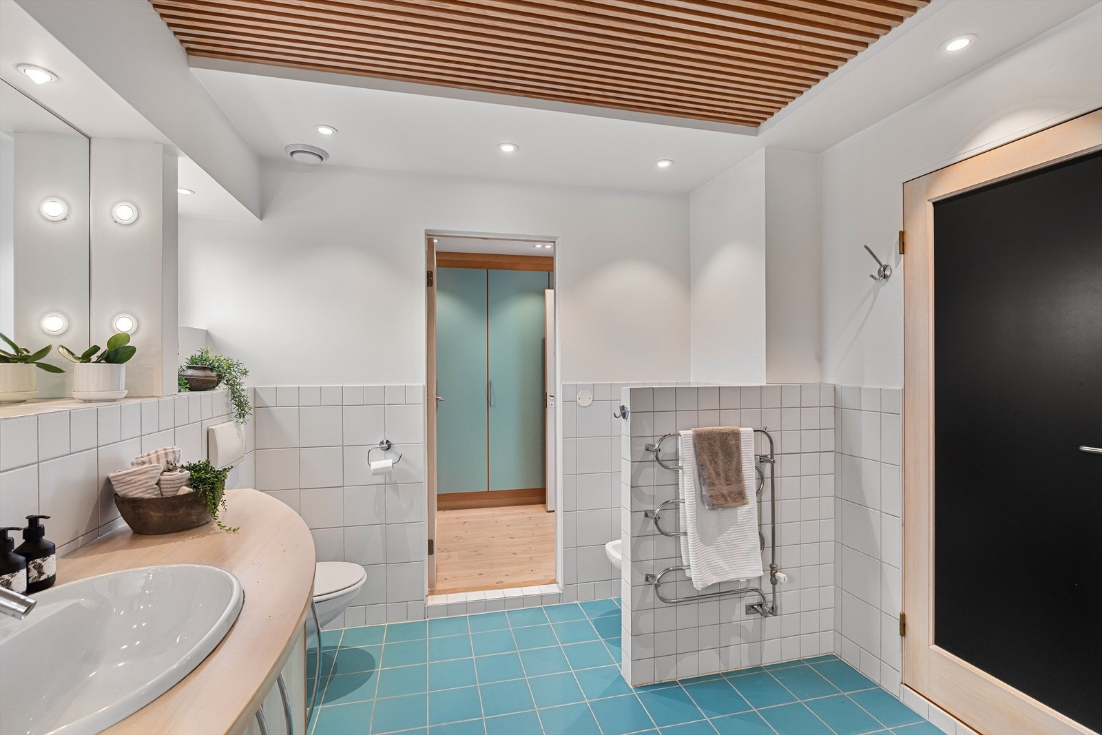 Stort og stilrent bad med flislagte overflater, downlights i himling og vannbåren varme i gulv. Galleribilde