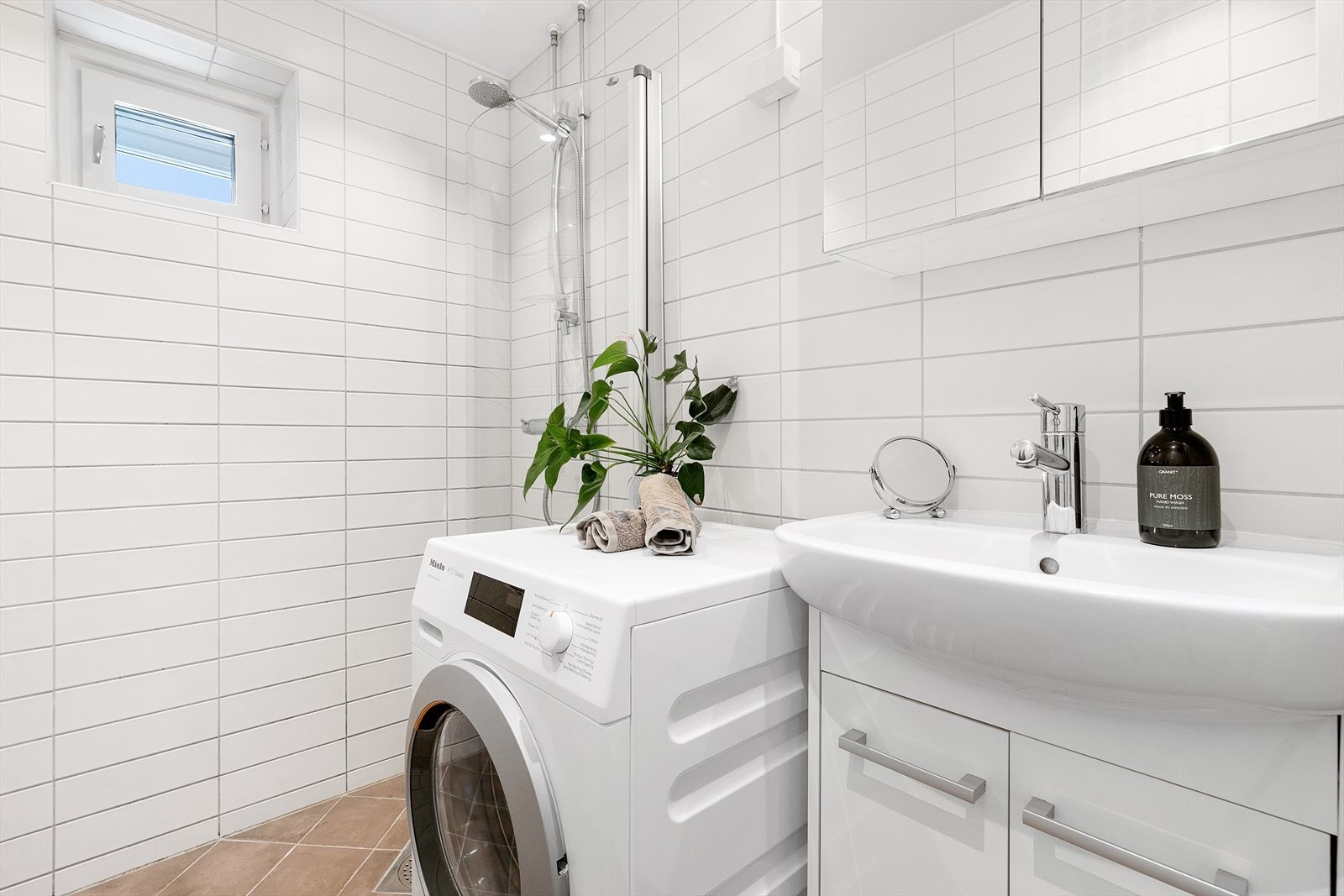 Baderommet er fra 2006 og framstår lyst og romslig.
Her får dere alt dere trenger med veggmontert dusjdør, servant med underskap,
speilskap med lys over og opplegg for vaskemaskin. Galleribilde