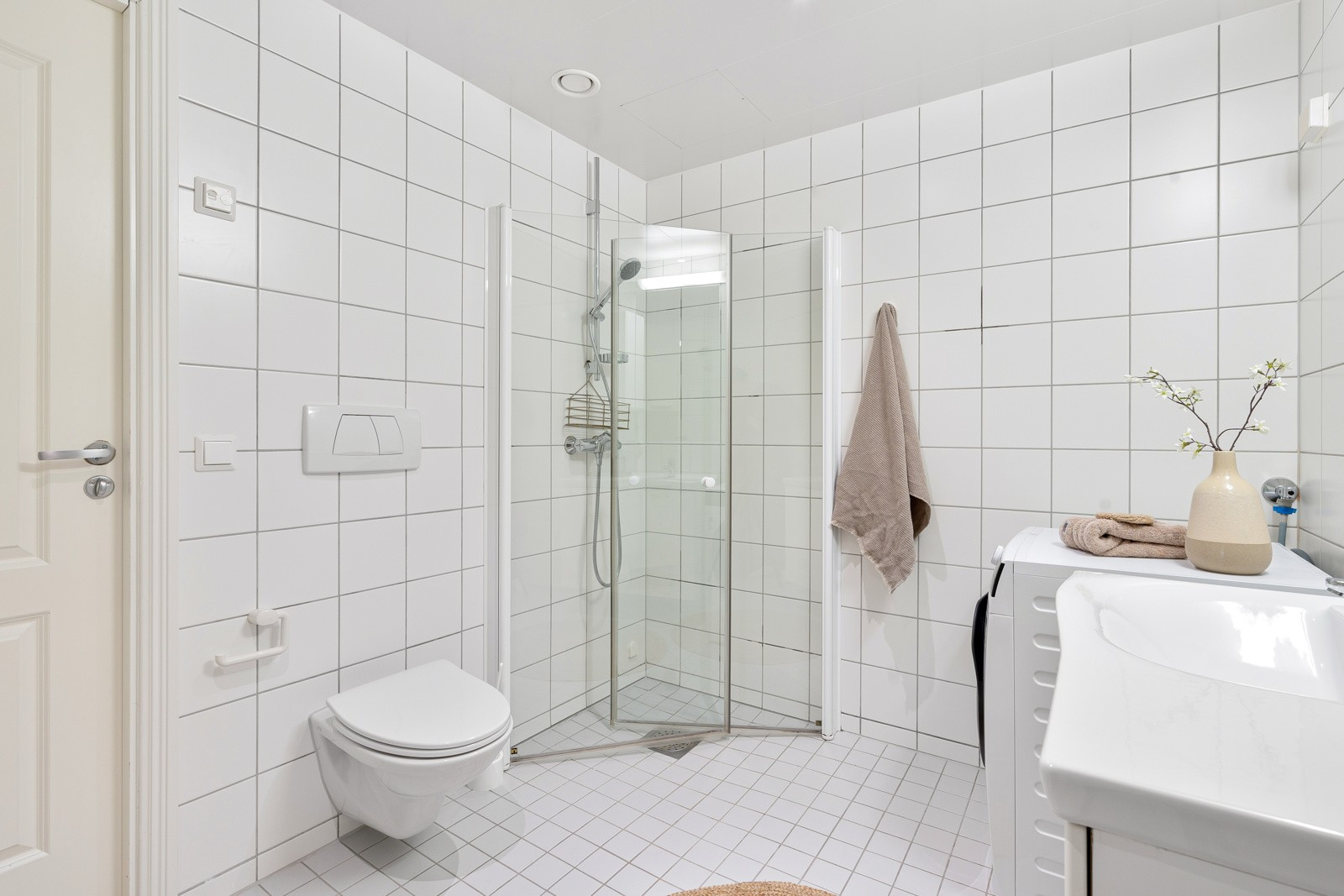 Badet inneholder vegghengt wc, servant og dusjhjørne