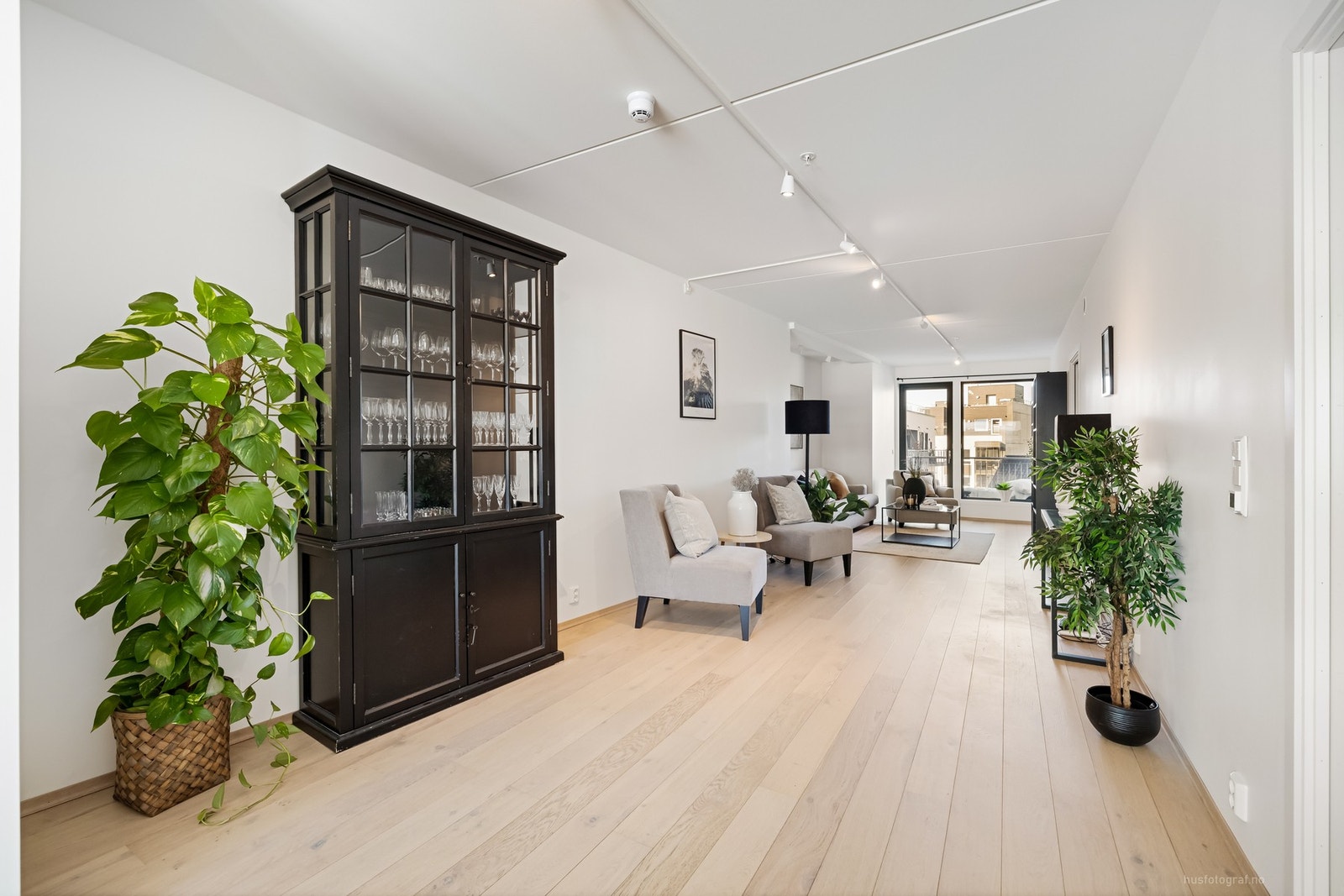 Romslig og lys stue med utgang vestvendt balkong mot rolig atrium Galleribilde