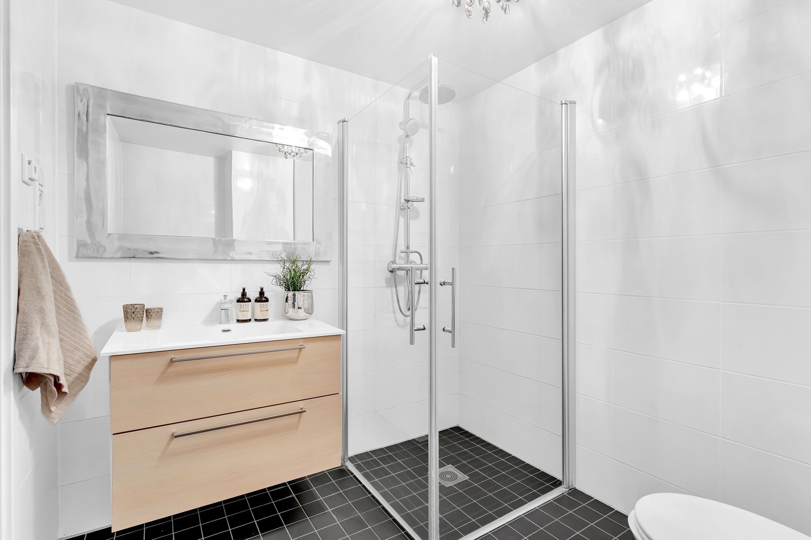 Badet har en tidsriktig innredning med grå fliser på gulv og hvite fliser på vegg, samt gulvvarme. Galleribilde