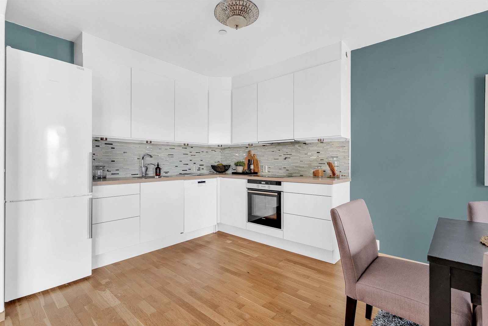 Kjøkkeninnredning består av glatte fronter, nedfelt oppvaskkum og 1-greps blandebatteri. Benkeplaten er av laminat og det er frittstående kjøl/frys og oppvaskmaskin. Det er integrert ovn og platetopp. Galleribilde