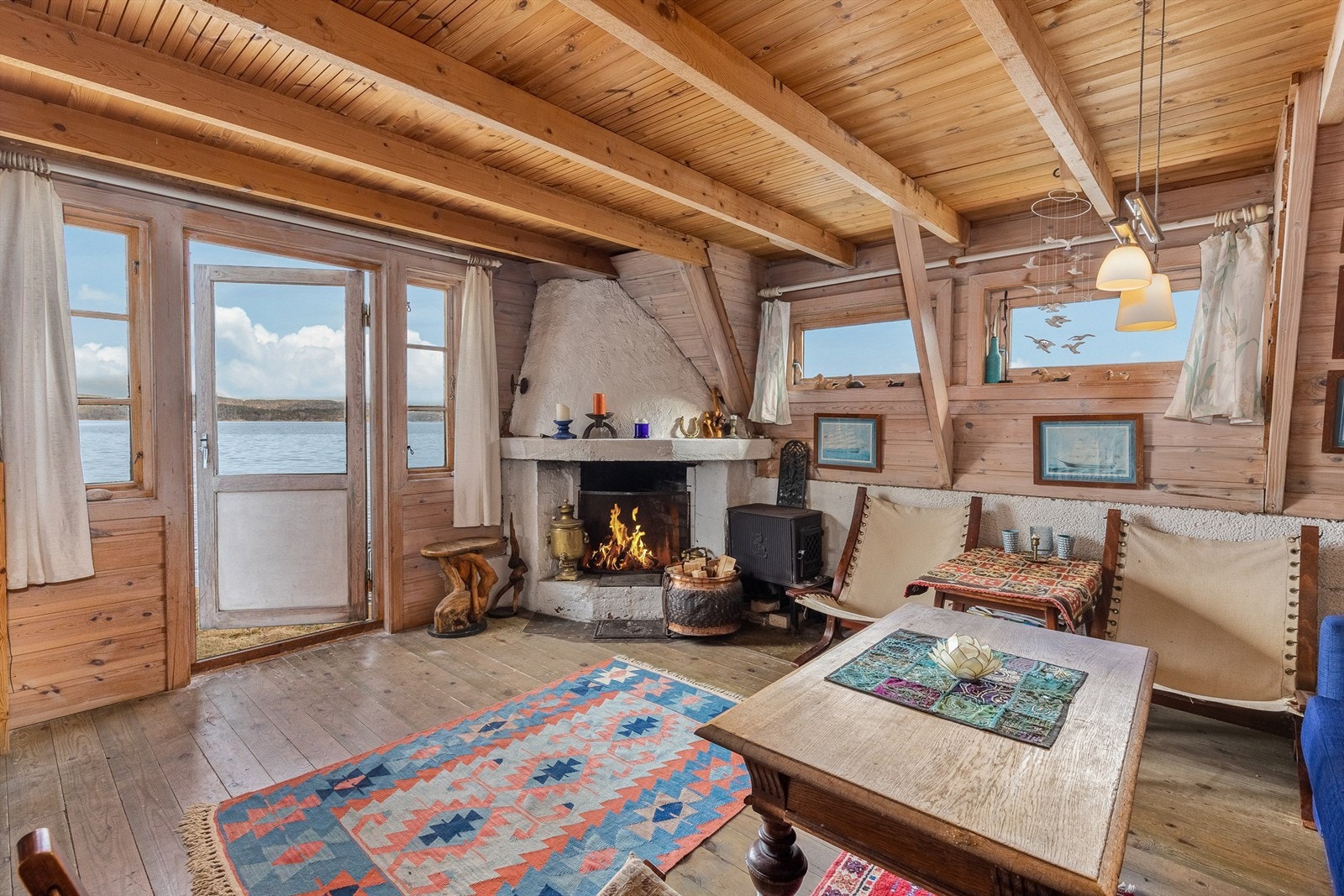 TETT PÅ SJØEN: Oppholdsrommet er åpent, lunt og intimt. Likevel virker det større siden vinduer mot sjøen fyller den lille hytta med naturen utenfor. Galleribilde