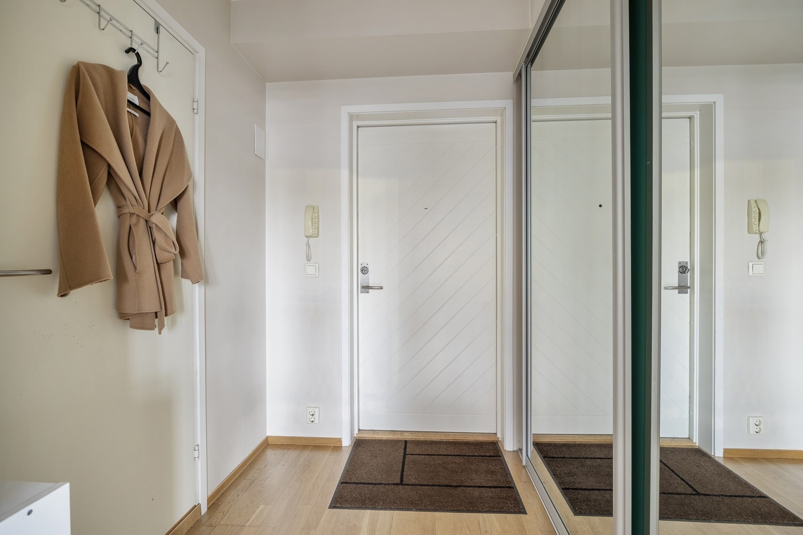 Innbydende entré med romslig skyvedørsgarderobe Galleribilde