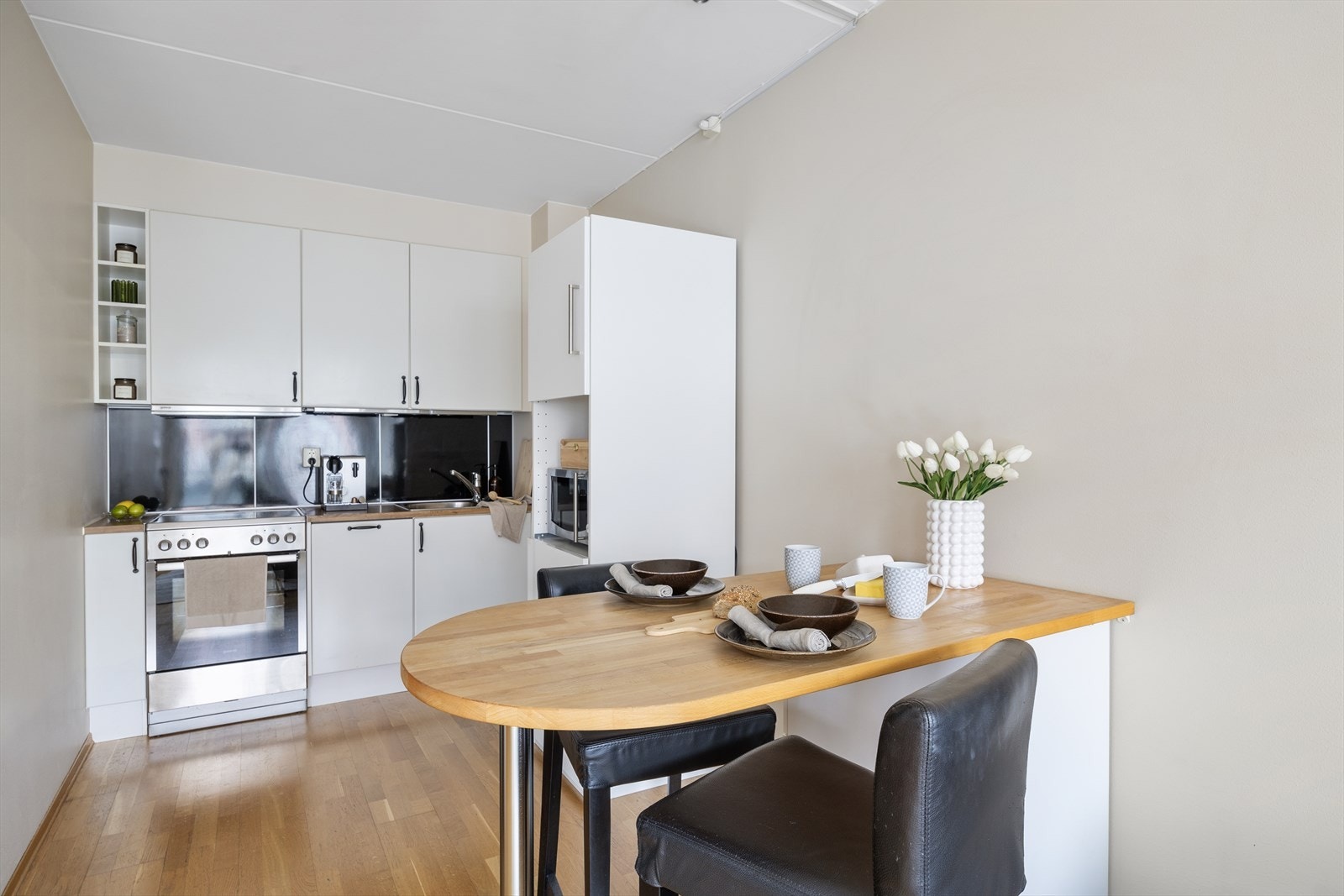 Kjøkken fra 2008 innredet hvite fronter og laminert benkeplate Galleribilde