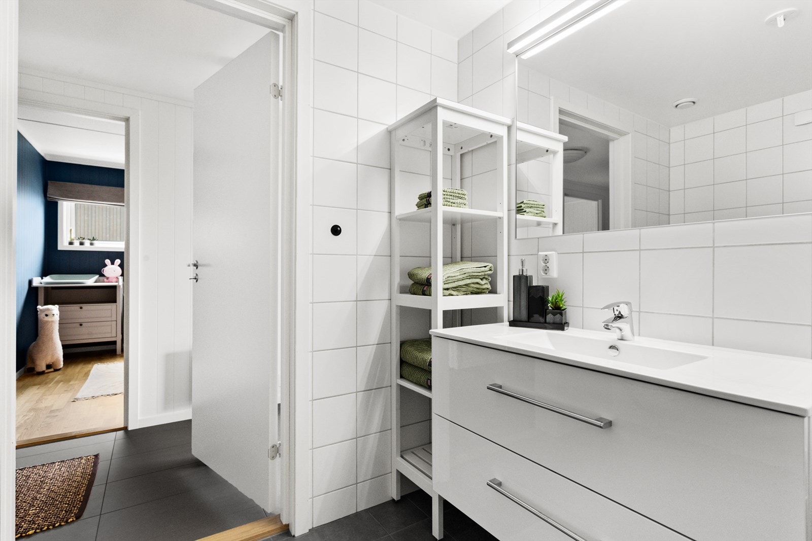 Badet er flislagt med hvite veggfliser og grå gulvfliser. Galleribilde
