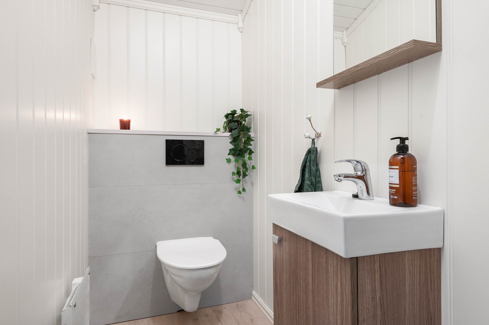 Toalettrommet har vegghengt toalett og en pen servantinnredning med tilhørende speil. Galleribilde