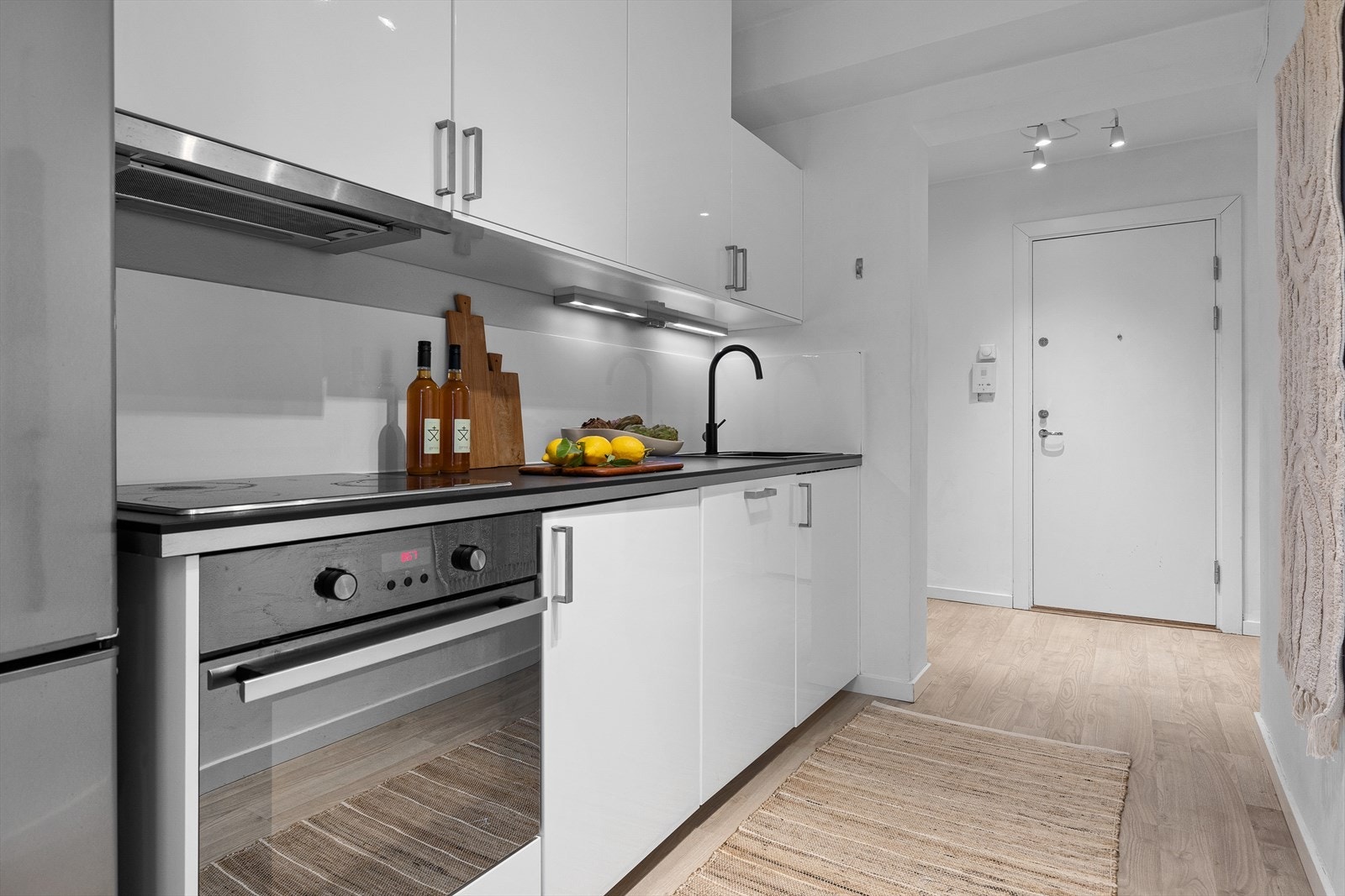 - Kjøkkeninnredning med glatte fronter. Det er laminat benkeplate med nedfelt vask - og skyllekum. Integrert platetopp, stekeovn og oppvaskmaskin. Avtrekk over kokeplass - Galleribilde