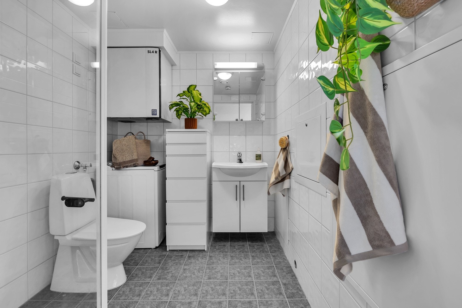 Badet i hovedleiligheten er pent og praktisk med fliser på gulv og vegger Galleribilde