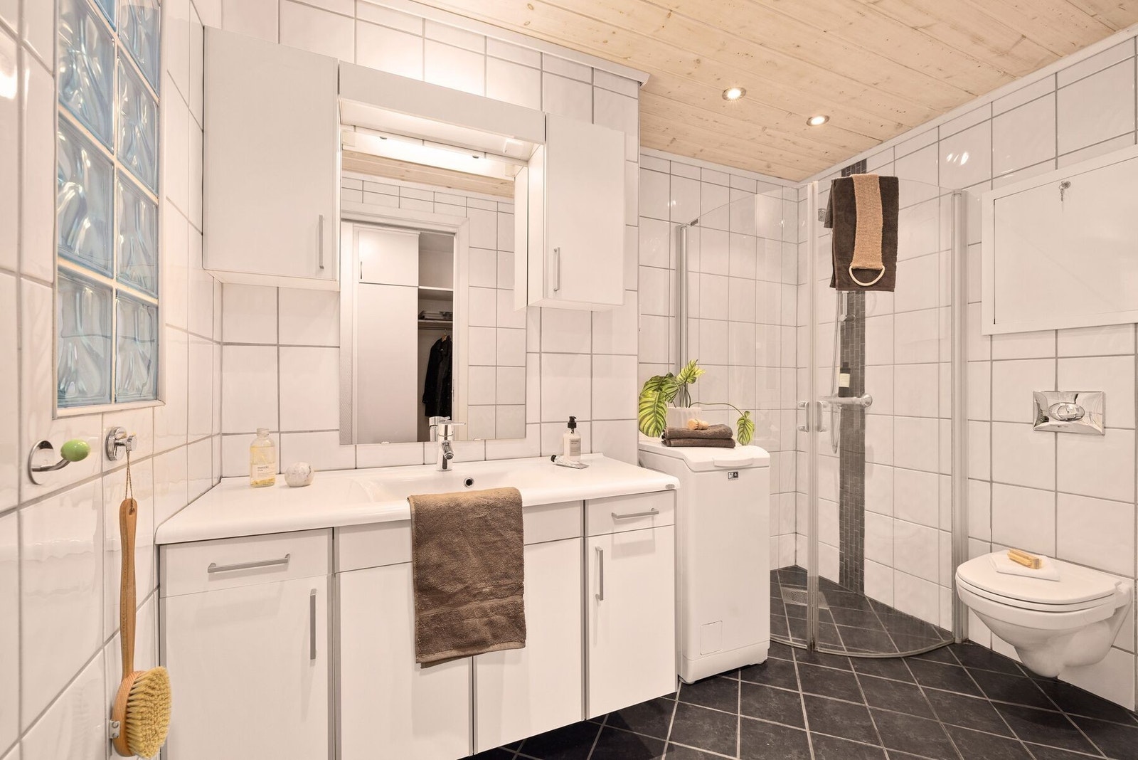 Badet har tilkomst fra gangen, er helfliset og har varme i gulv. Galleribilde
