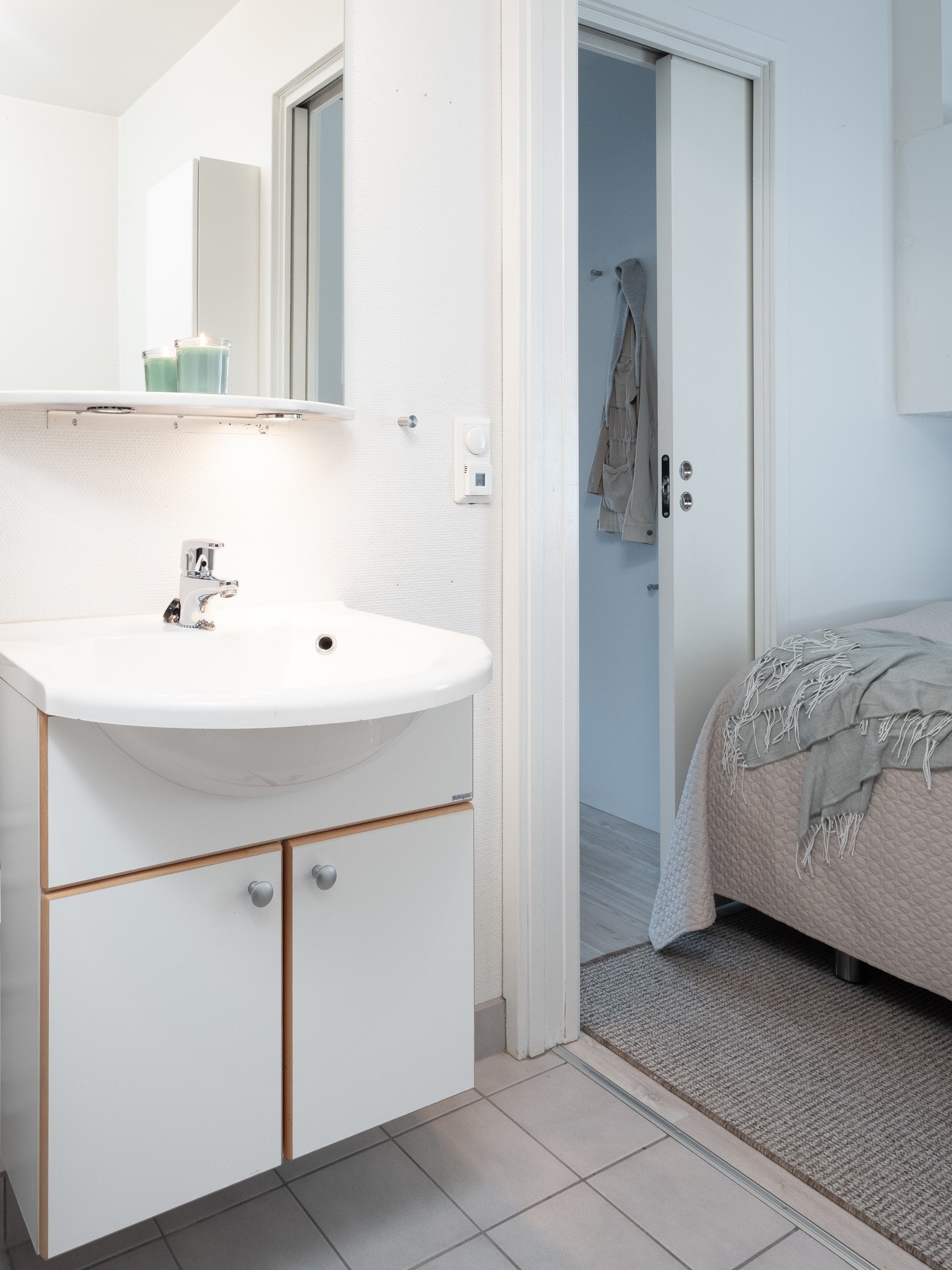 Badet har flis på gulv med varmekabler og servant med underskap. Galleribilde