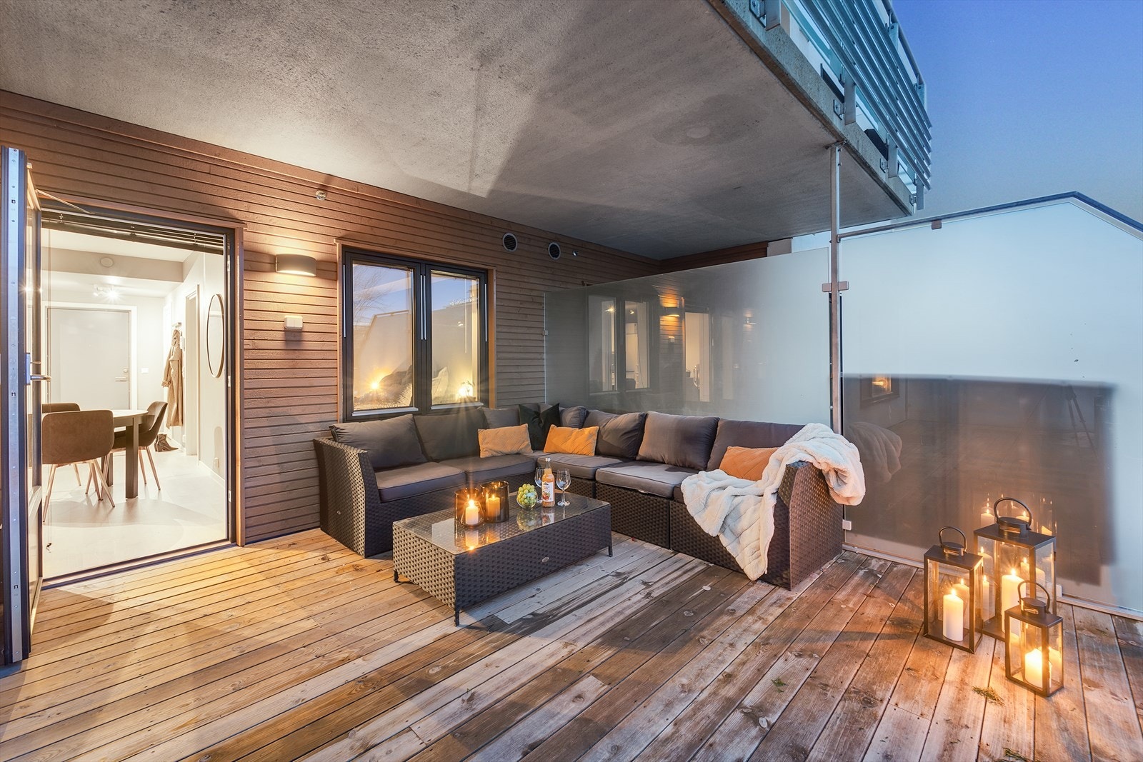 Stor terrasse med utgang fra stuen, med trykkimpregnert terrassebord, levegger i stålramme og frostet glass. Galleribilde