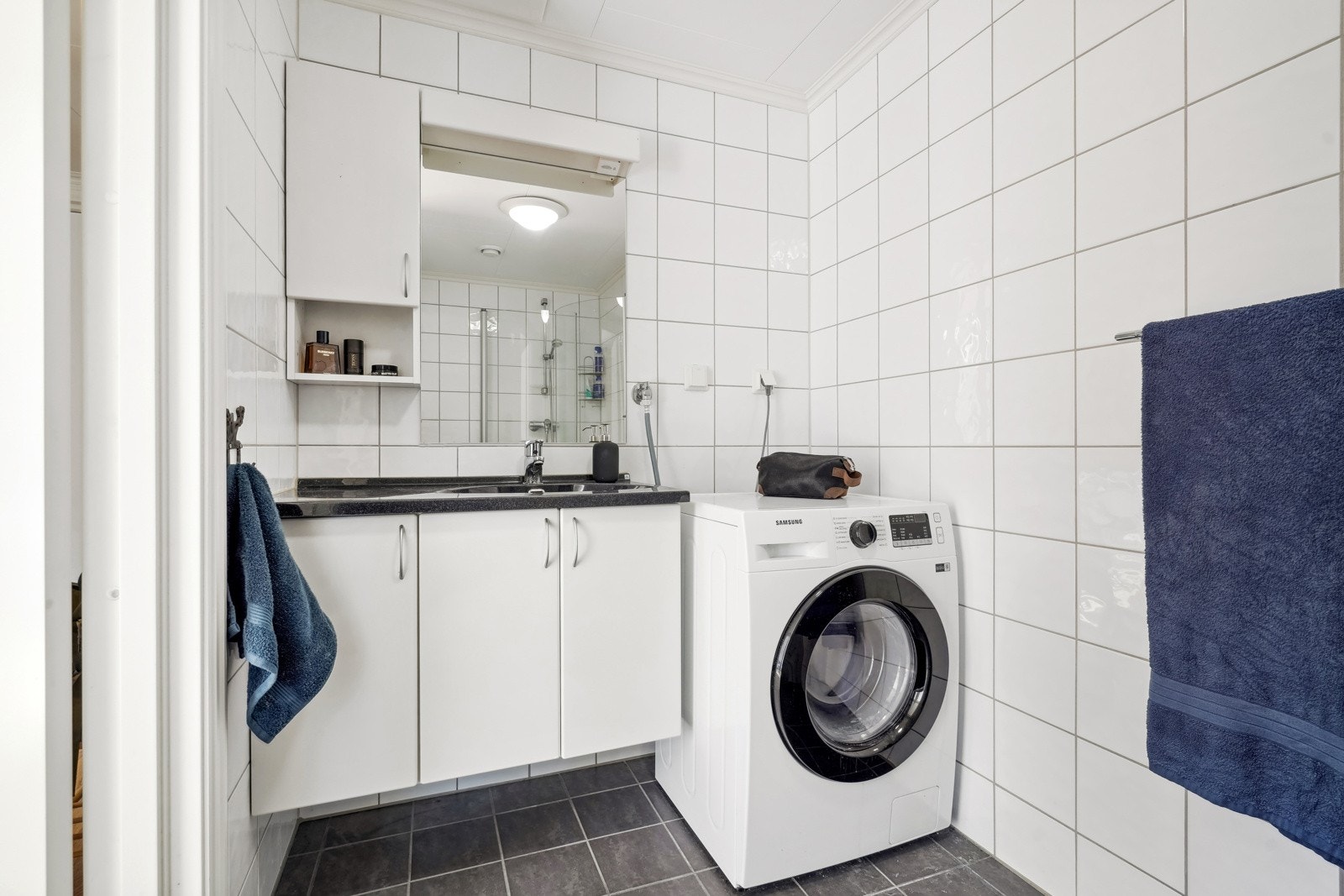 Helfliset bad utstyrt med gulvvarme, dusj, gulvstående toalett, servantskap og opplegg for vaskemaskin. Galleribilde