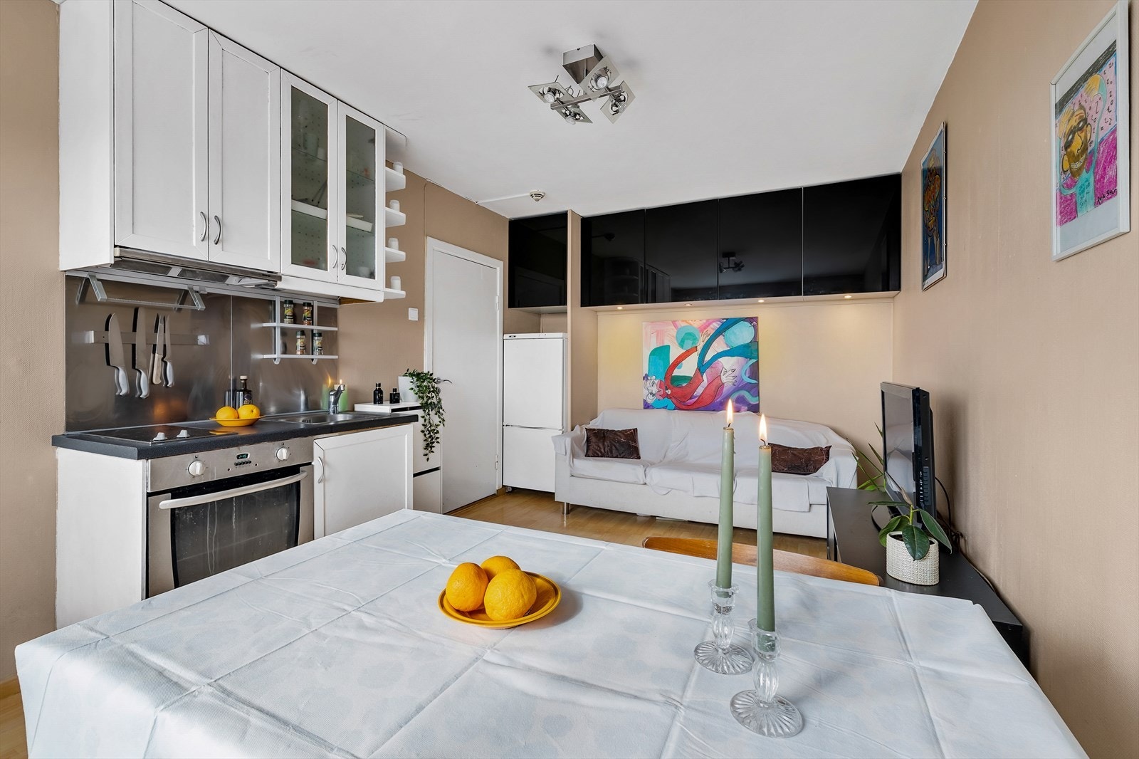 Lagringsplass i overskap over kjøkkenbenken og sofa. Galleribilde