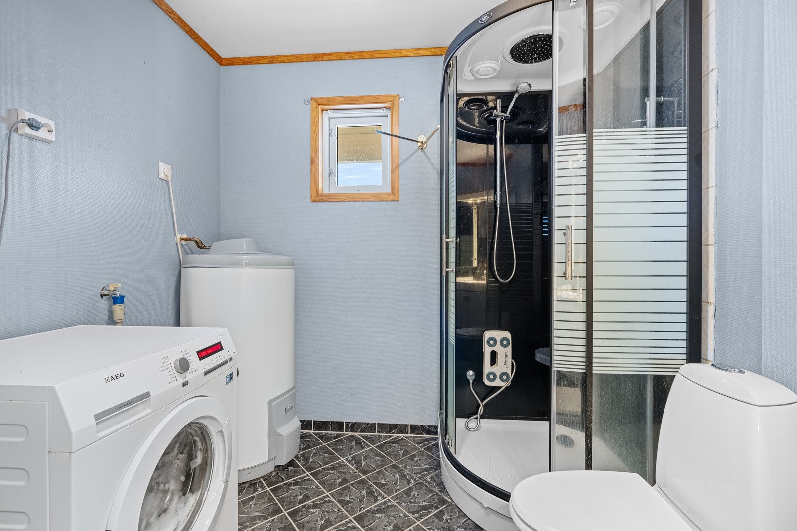 Bad med toalett, dusjkabinett og opplegg til vaskemaskin Galleribilde