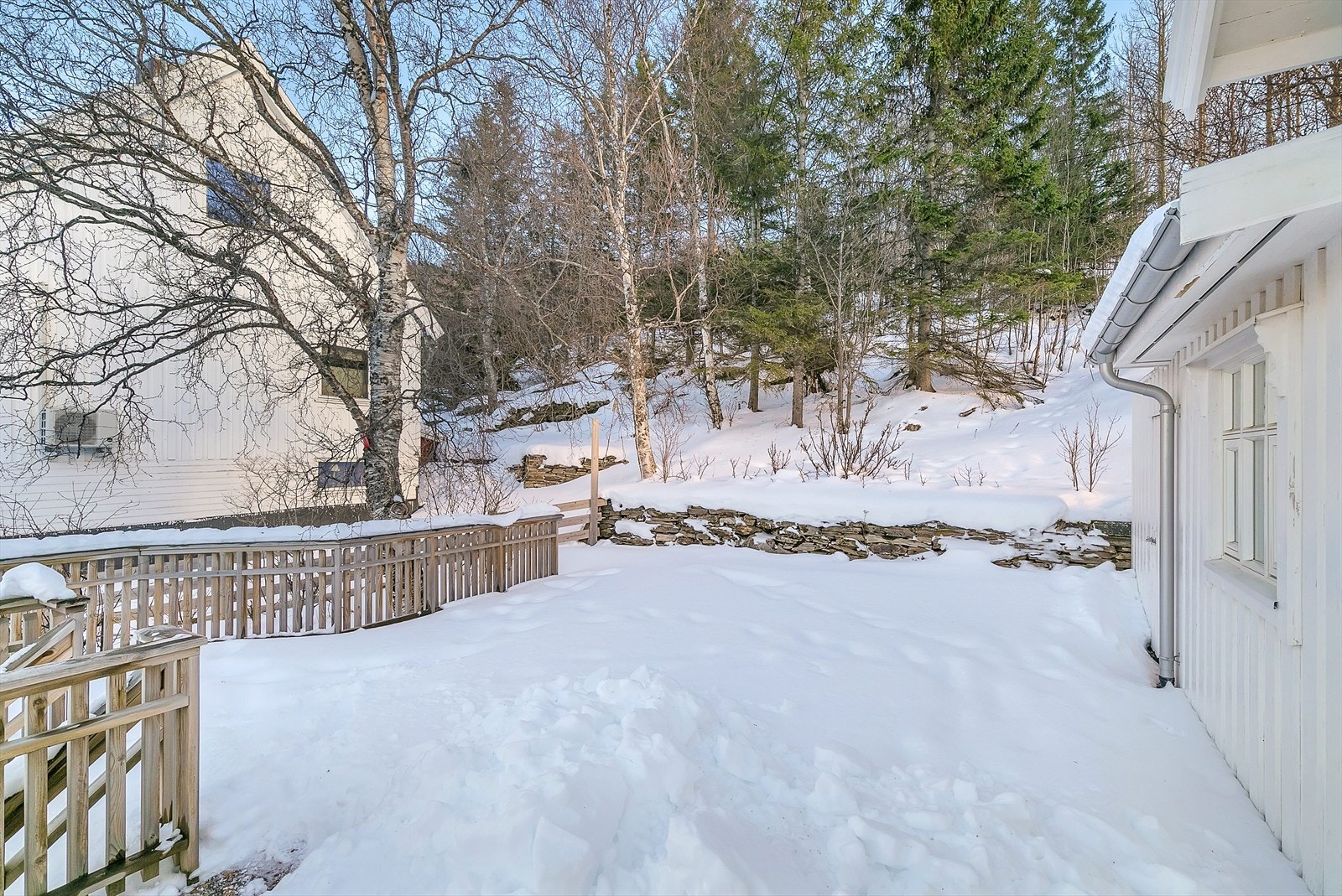 Velordnet og opparbeidet eiendom med innbydende mur og rekkverk omkring terrassen. Galleribilde