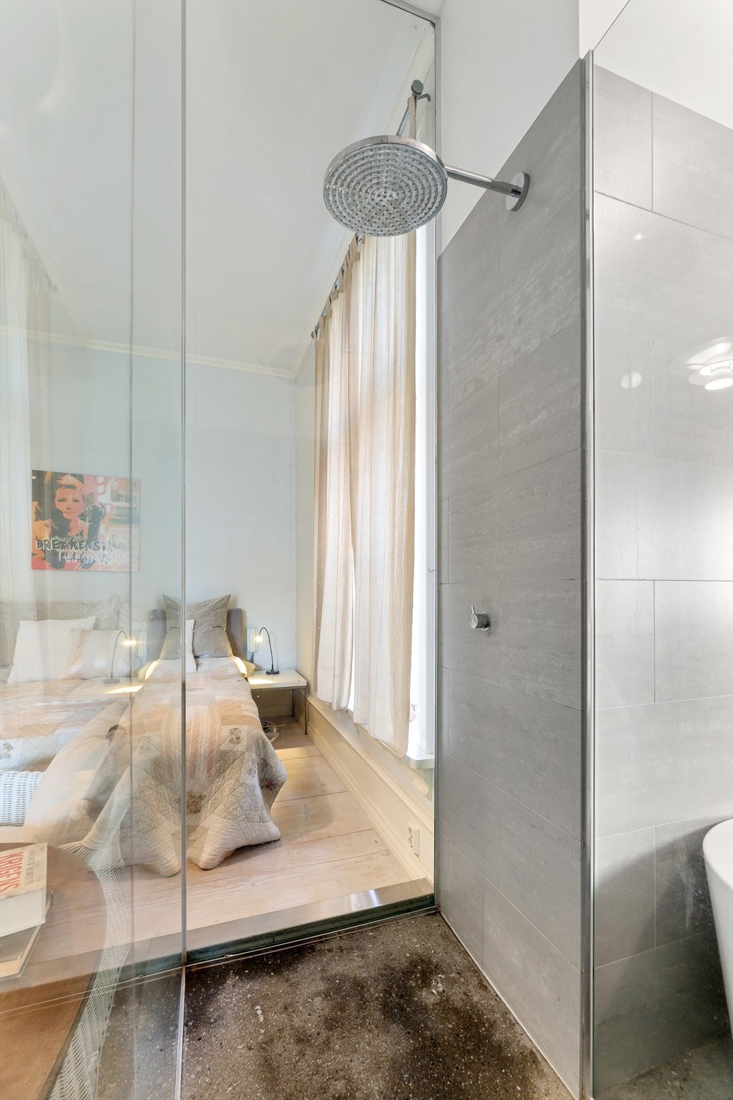 Badet har flislagte vegger og slipt betonggulv. Vegger i dusjen mot soverom er i glass. Galleribilde