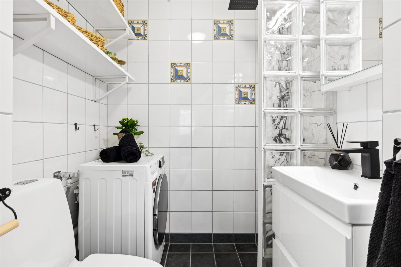 Badet har fliser på gulv og vegger, standard innredning, gulvvarme og dusjhjørne. Galleribilde