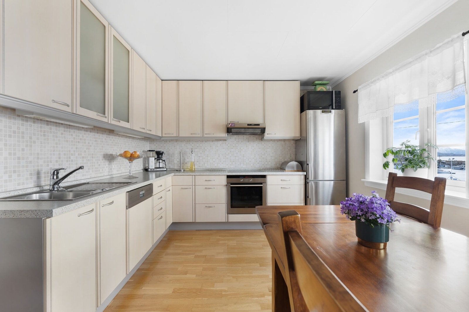 Eldre kjøkken med slette fronter og laminert benkeplate - frittstående kjøleskap. Galleribilde