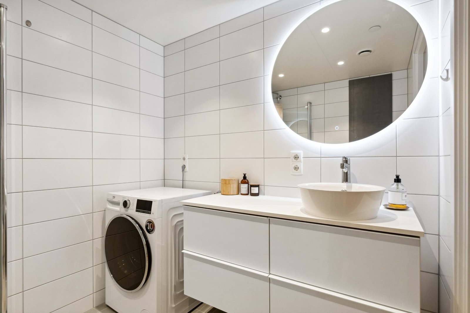 Badet fremstår lekkert og moderne. Elektriske varmekabler i det flislagte baderomsgulvet, flis på vegger og malt overflate med downlights i himling. Galleribilde