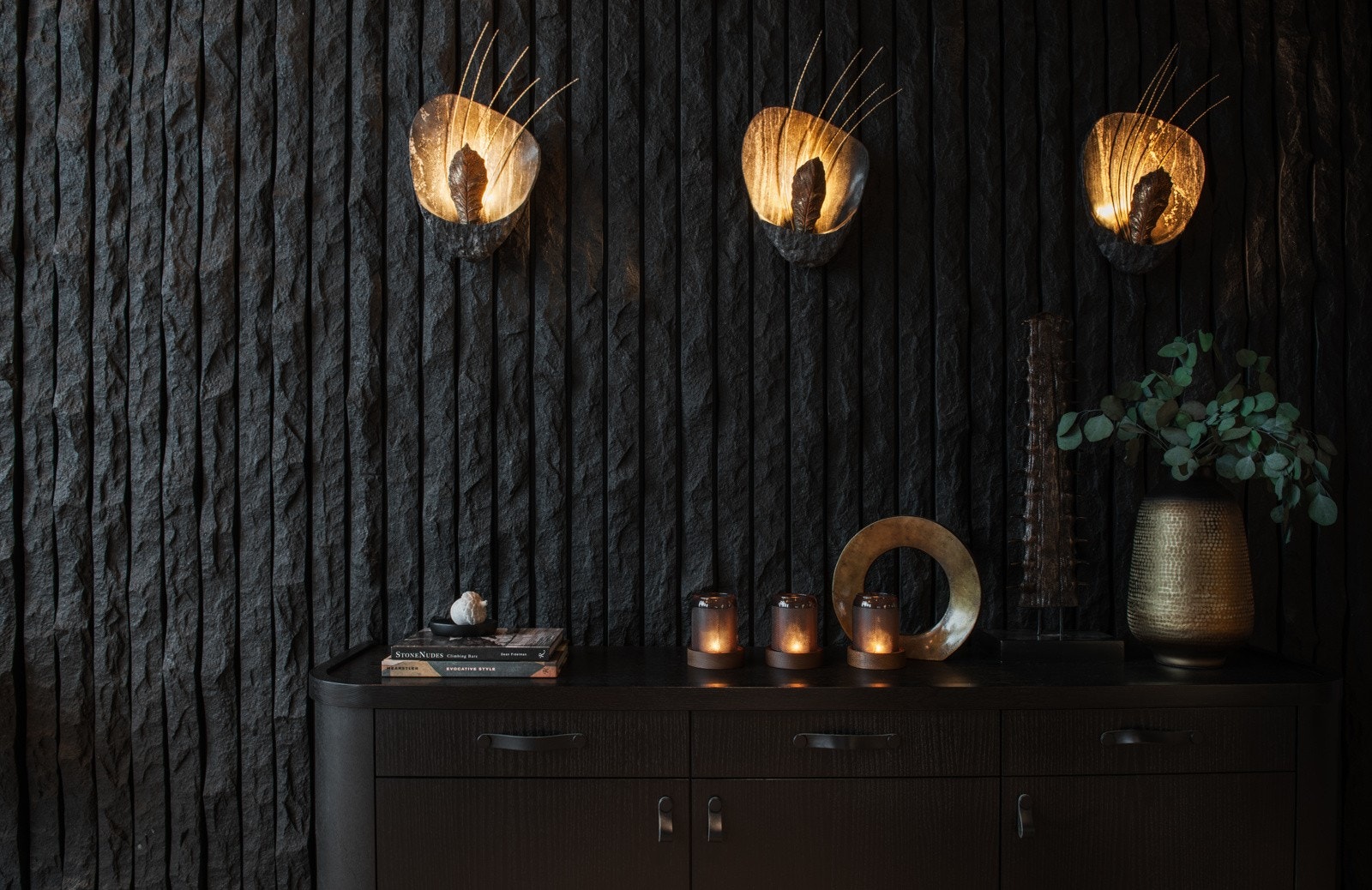 Stenmuren bak peisen er laget av naturlig granittstein. Hver stripe sten er hugget for hånd for å lage den spesielle, kurvede overflaten. Selv lampene på veggen er spesiallaget! Galleribilde