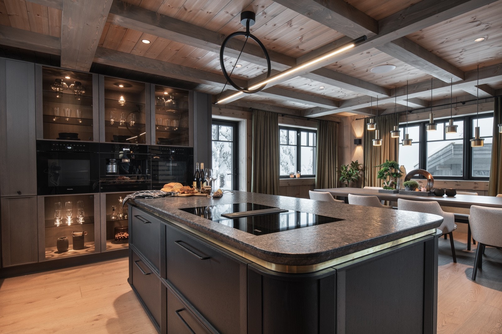 Videre finner man integrert kaffemaskin, to stekeovner, tallerkenvarmer kokeplate på kjøkkenøy med integrert ventilator. Alt fra Miele Galleribilde