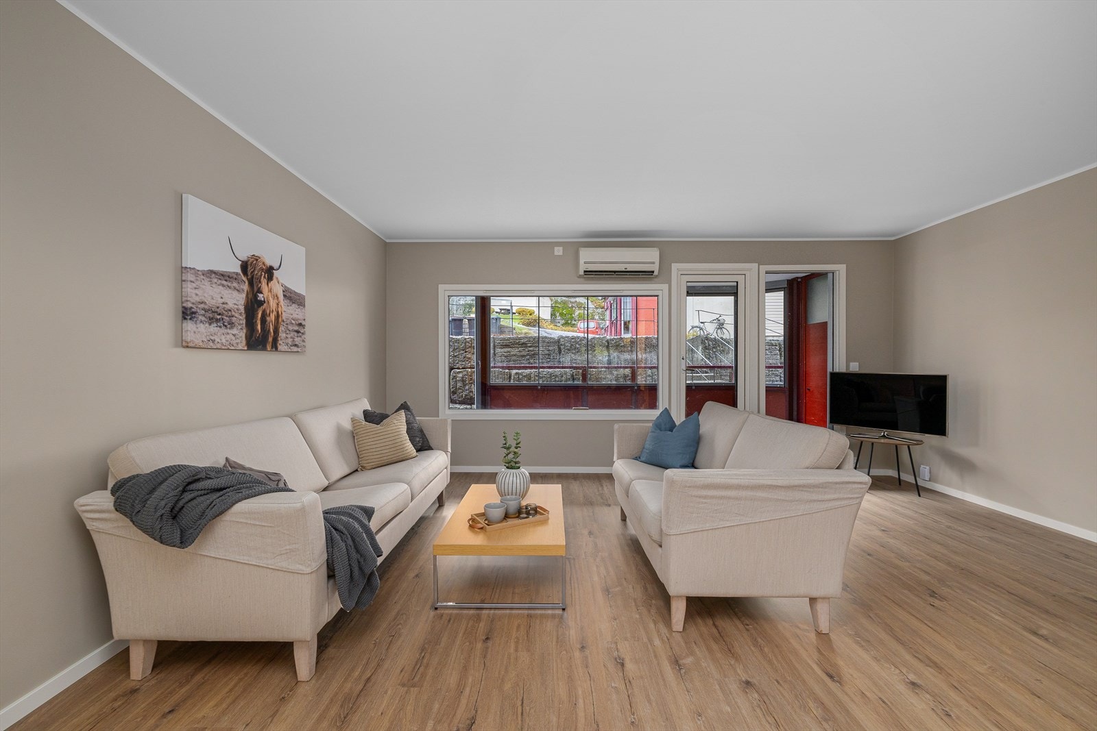 Store vindusflater og terrassedør gir rikelig med lys til rommet. Galleribilde