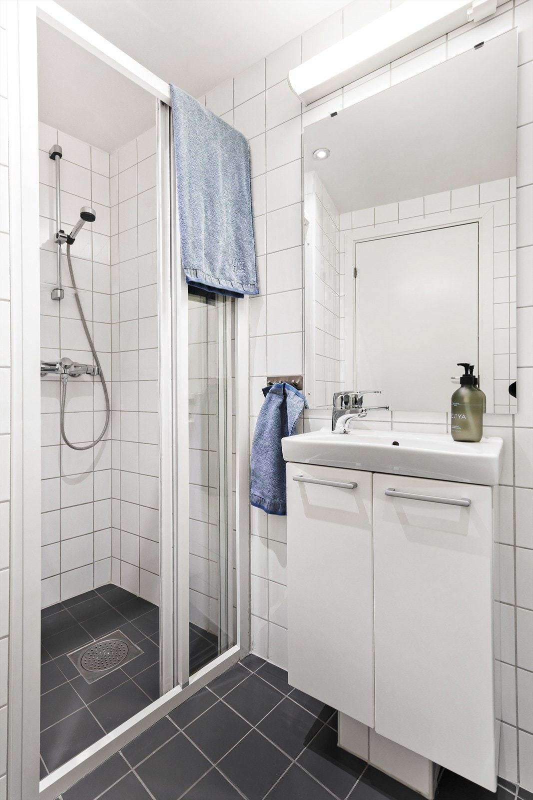 Badet er tidløst og flislagt med dusj, servantskap, vegghengt toalett og opplegg for vaskemaskin. Galleribilde