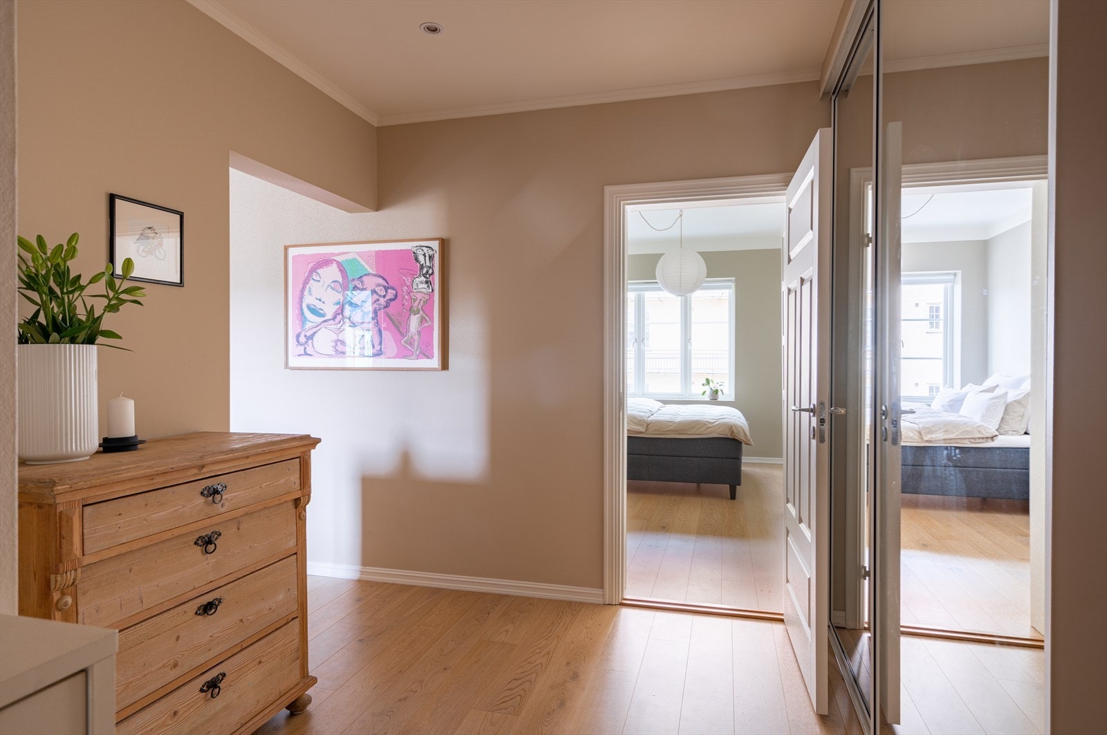 Innbydende entré med lysmalte overflater og innfelte lys i himling som gir et godt førsteinntrykk av leiligheten. Galleribilde