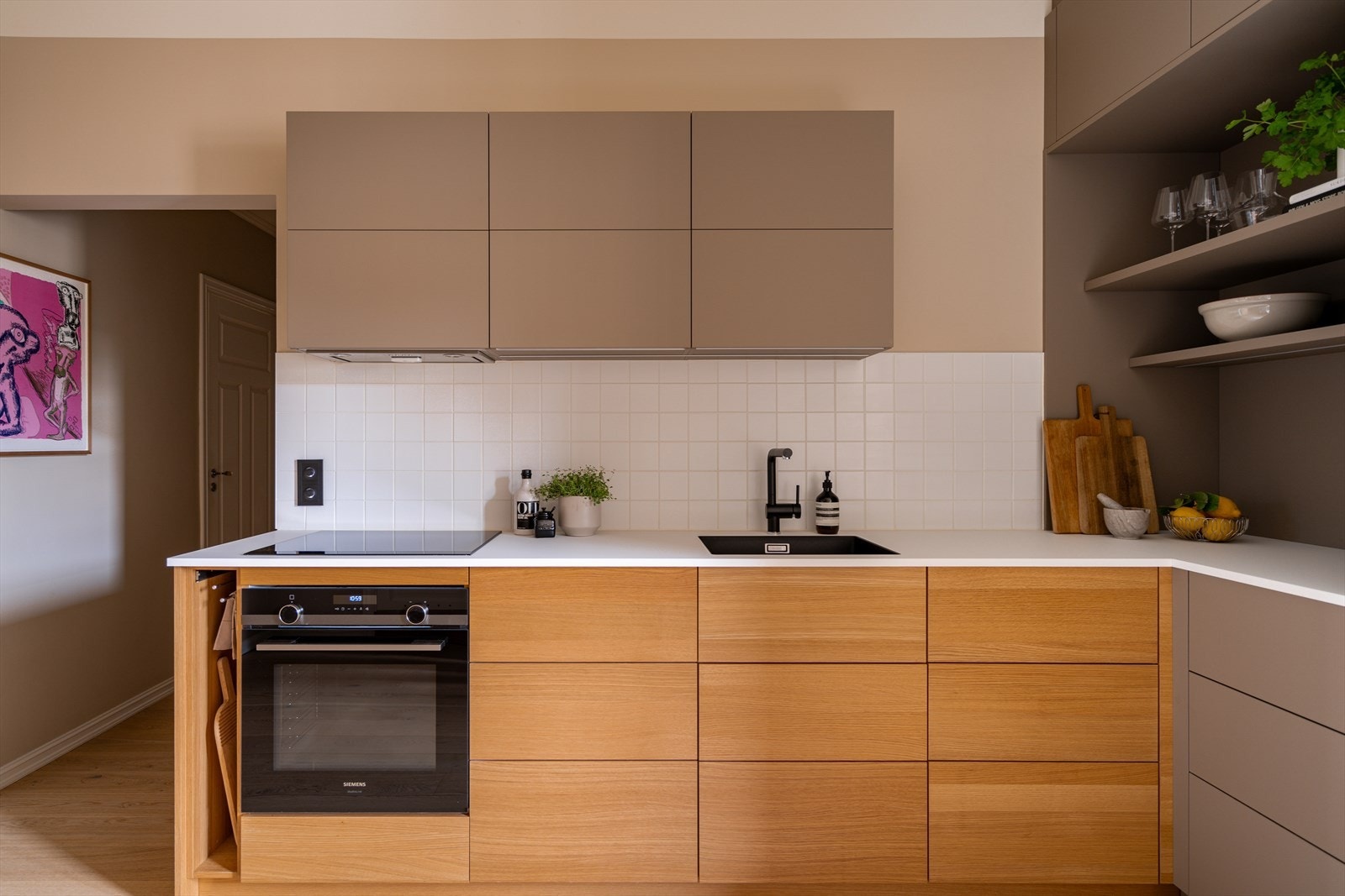 Innredningen består av fronter i eikefinér og matt laminat, benkeplate i kompaktlaminat, underlimt oppvaskkum og fliser over benkeskap. Galleribilde