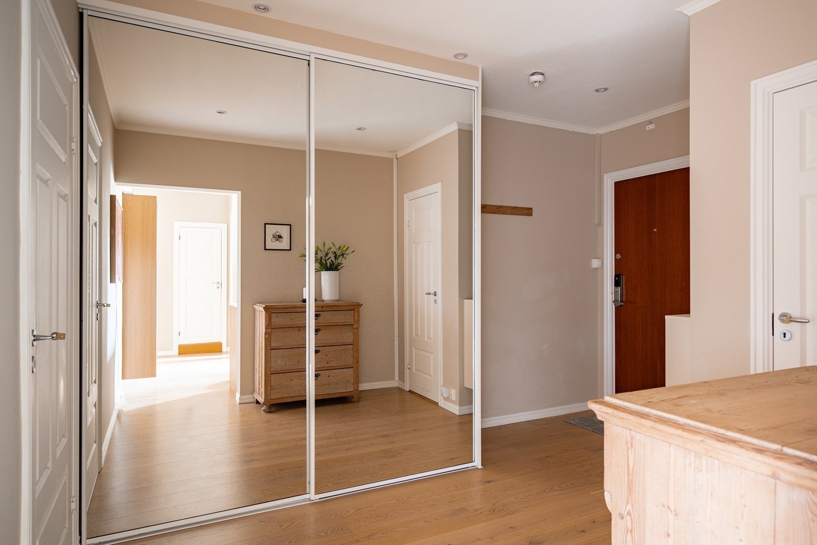 God plass til oppbevaring av yttertøy og sko i stor skyvedørsgarderobe med speildører. Galleribilde