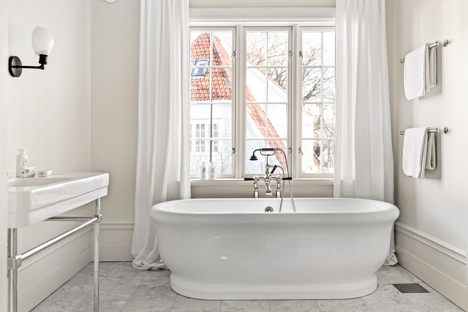 Hovedbadet har stedbygget dusjnisje og et romslig badekar. Marmor på gulv. Galleribilde