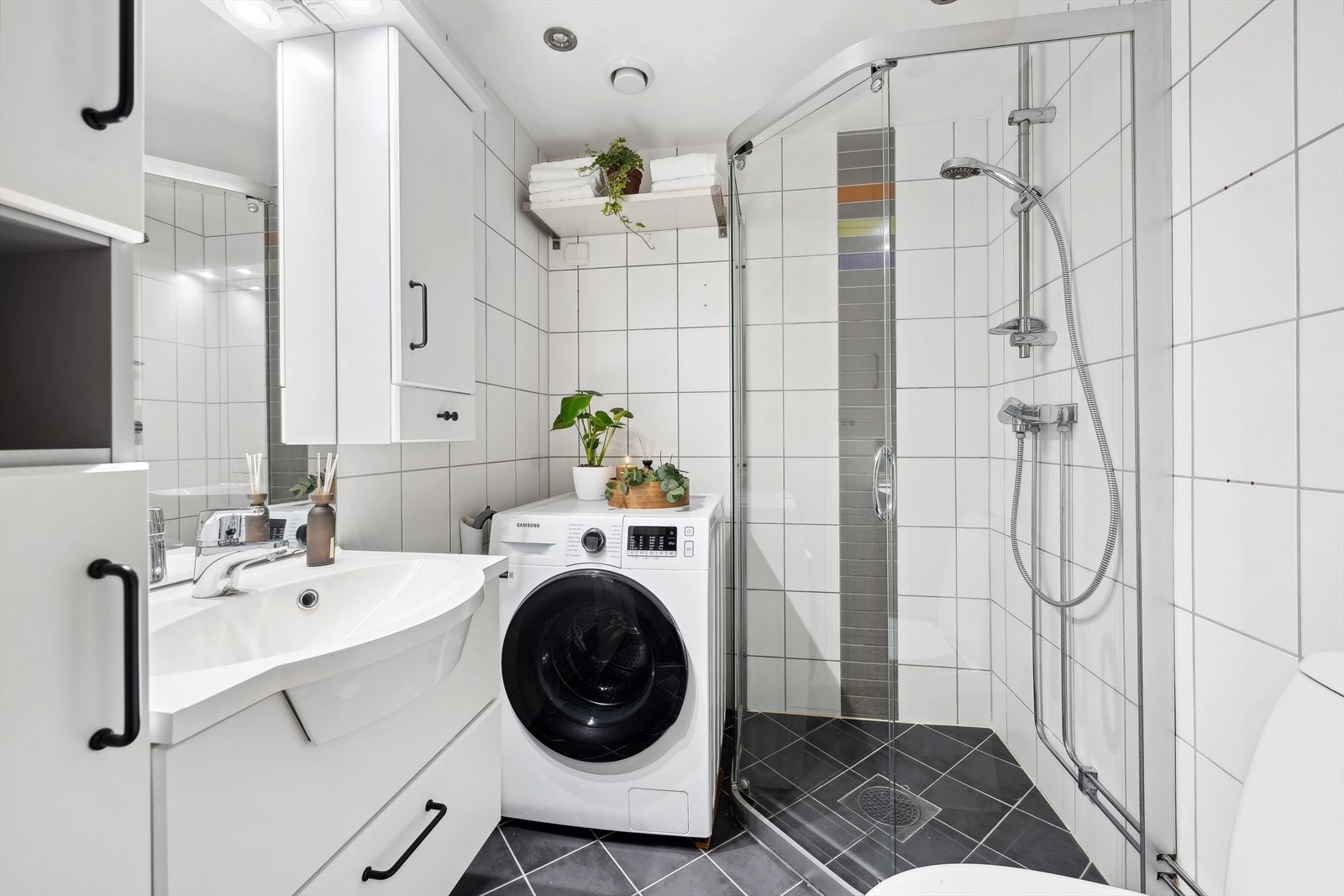 Stilrent, flislagt baderom med vannbåren varme i gulv og spotter i himling. Baderommet har opplegg til vaskemaskin. Galleribilde