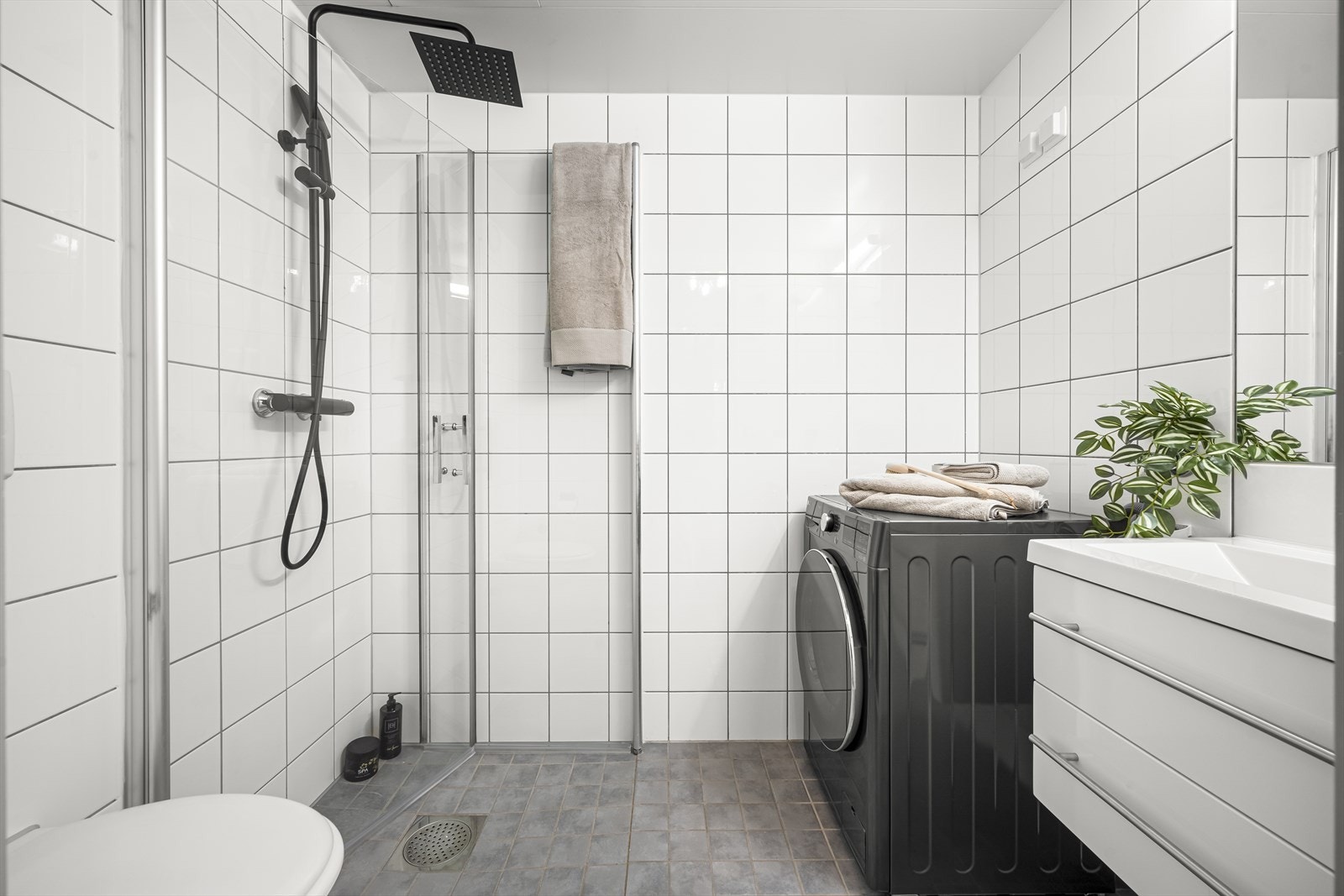 Pent flislagt baderom med gulvvarme og opplegg for vaskemaskin. Galleribilde