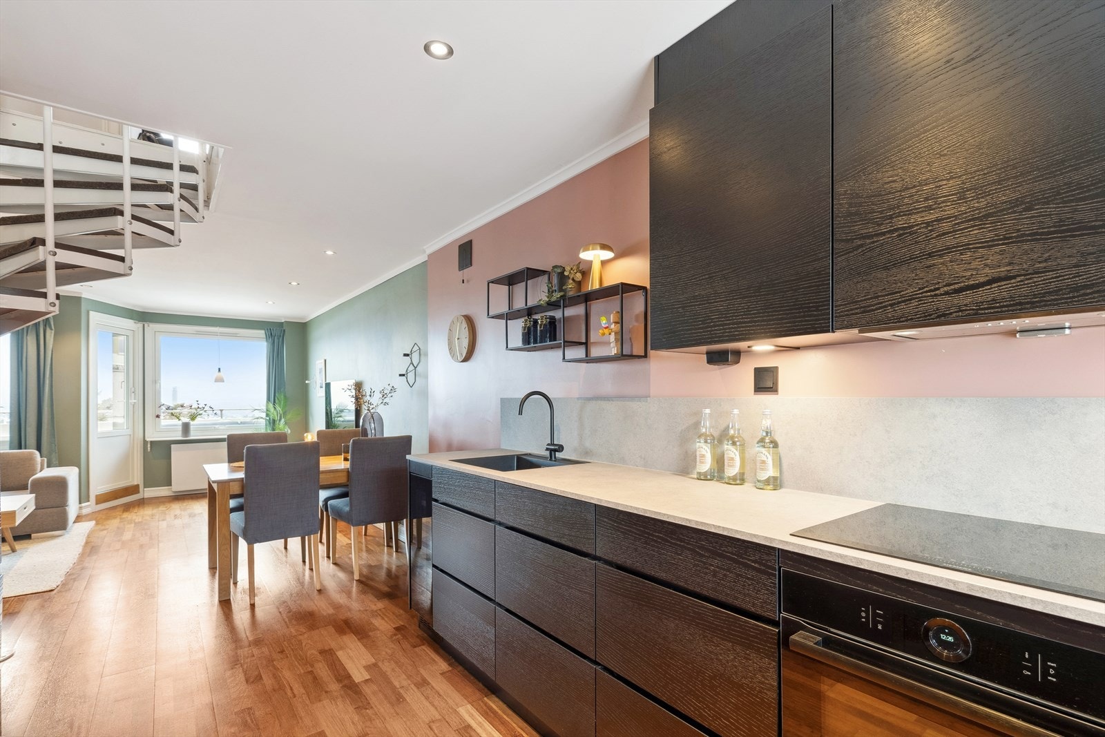 Kjøkkenet ligger i en åpen løsning mot stuen, som gjør det enkelt å kombinere matlaging med sosialt samvær. Galleribilde