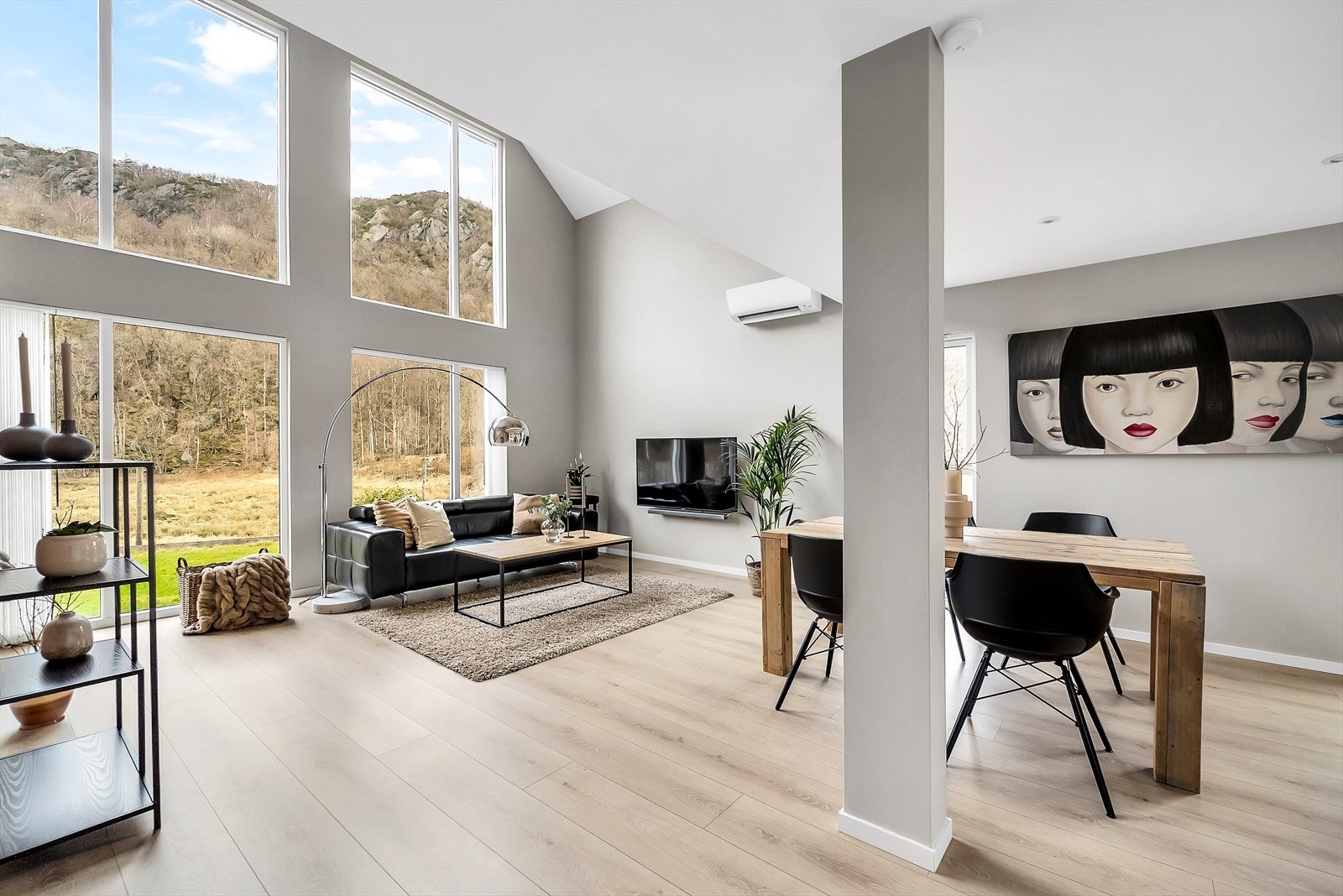 Store vindusflater gir godt med lys inn i stua. Varmepumpe på vegg. Galleribilde