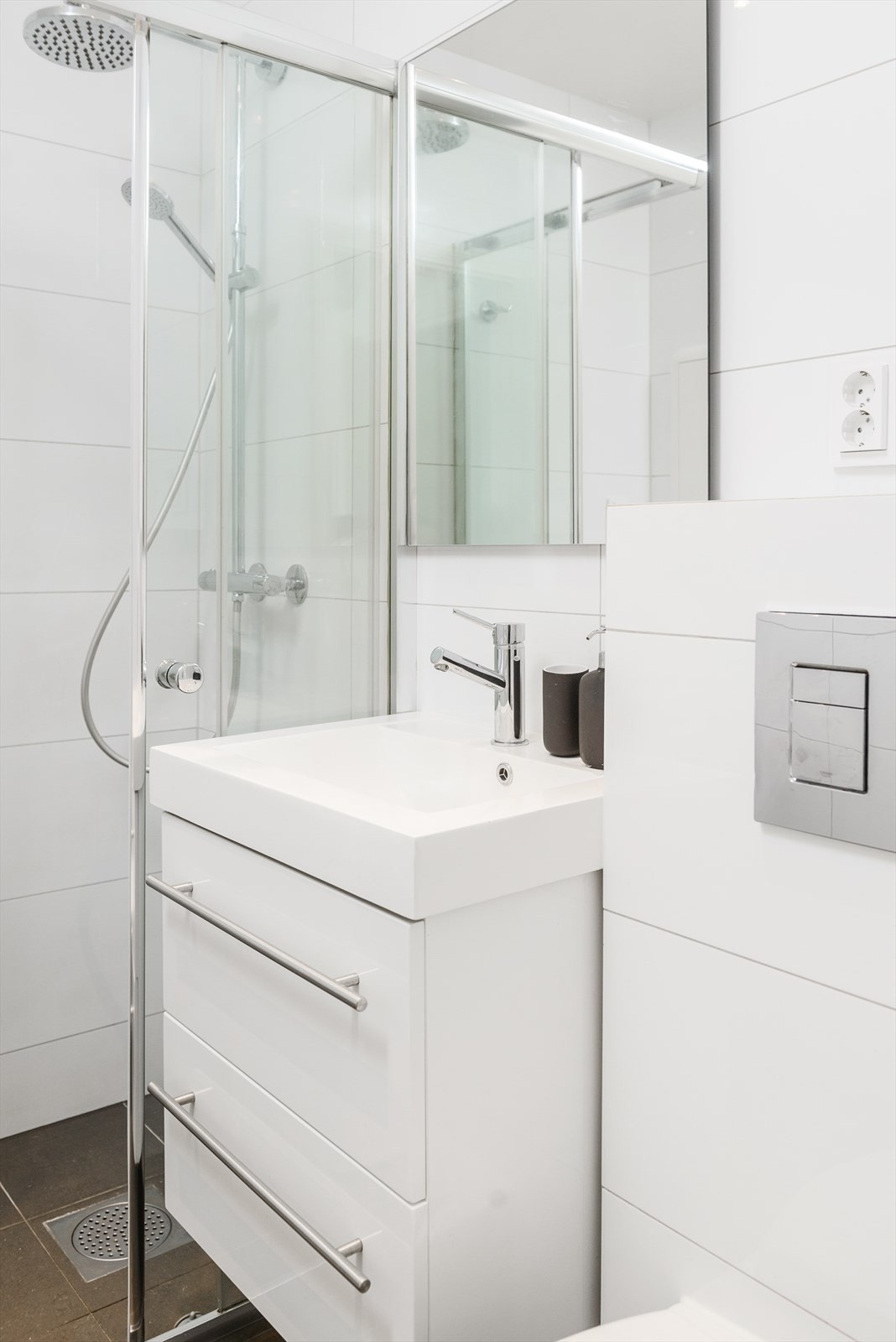 Badet har lekker innredning i høyglans, vegghengt toalett og plass til vaskemaskin Galleribilde