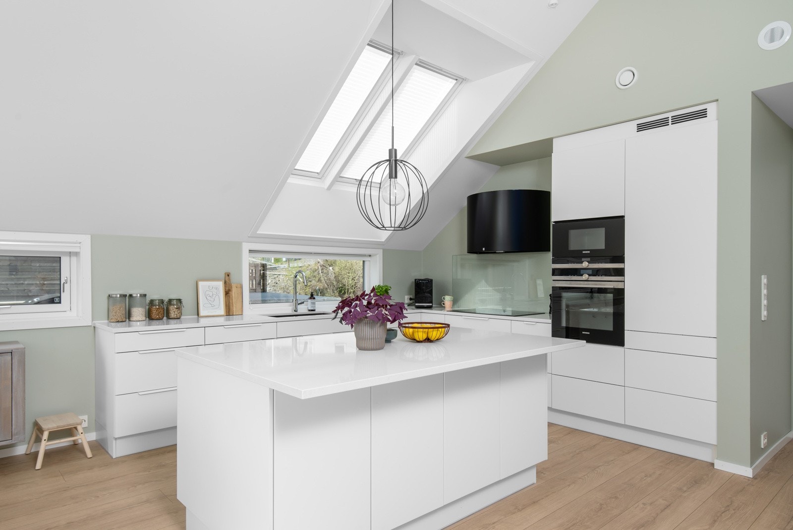 Lys kjøkkeninnredning med integrerte hvitevarer. Galleribilde