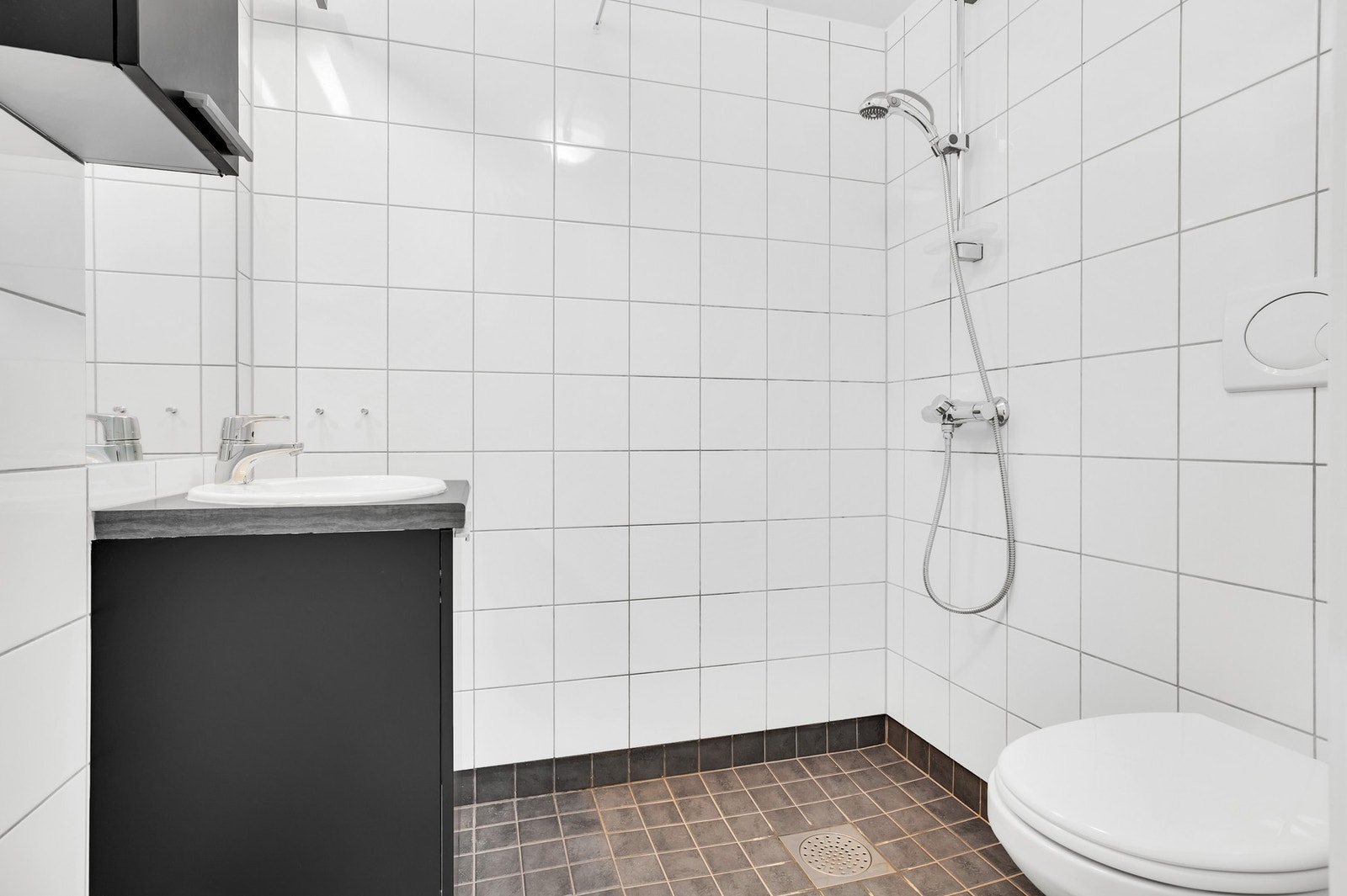 Badet har flis på vegg og gulv, vegghengt WC og servant med underskap. Galleribilde