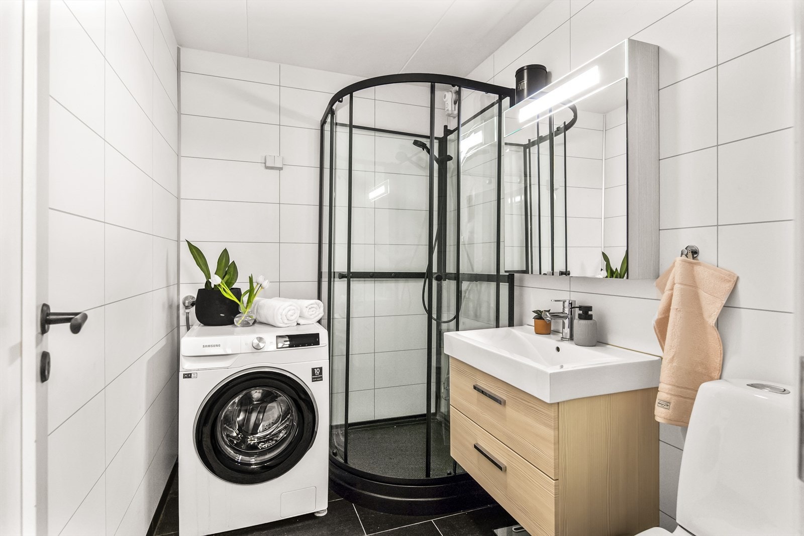 Gå videre inn i det delikate og flislagte badet, oppgradert i 2009, komplett med dusjkabinett, vaskeservant i innredning og toalett, samt praktisk opplegg for vaskemaskin. Galleribilde